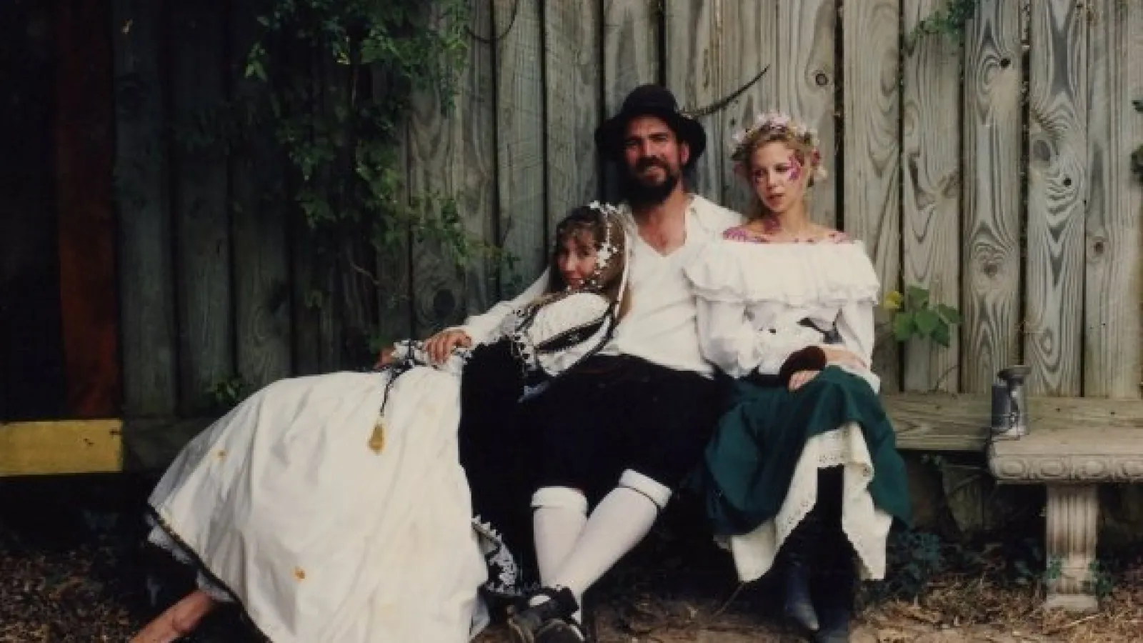 a man and a woman sitting on a bench posing for the camera