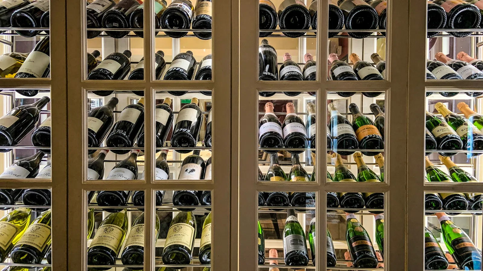 Elegant wine cellar filled with various bottles showcasing diverse labels and colors.