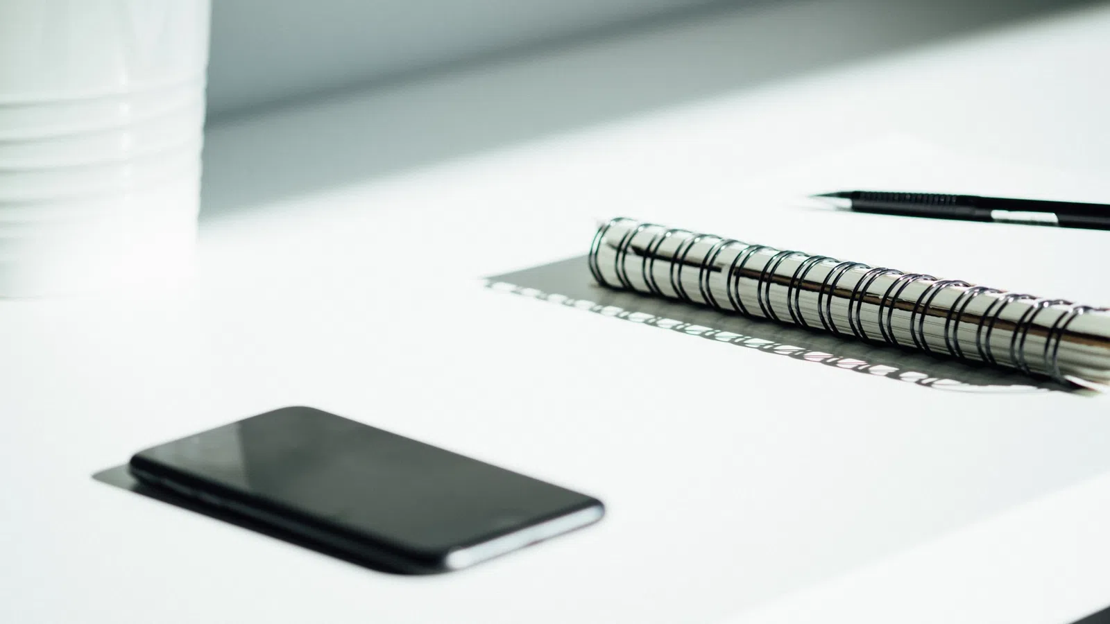 a pen and a cell phone on a table
