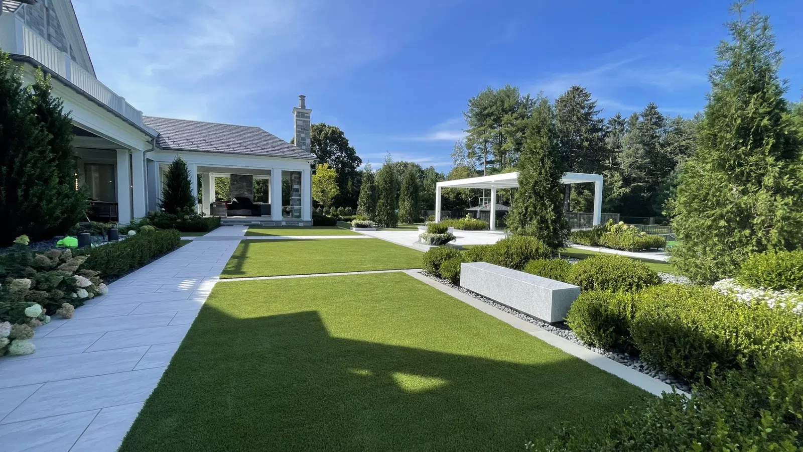a large green lawn with a house in the background