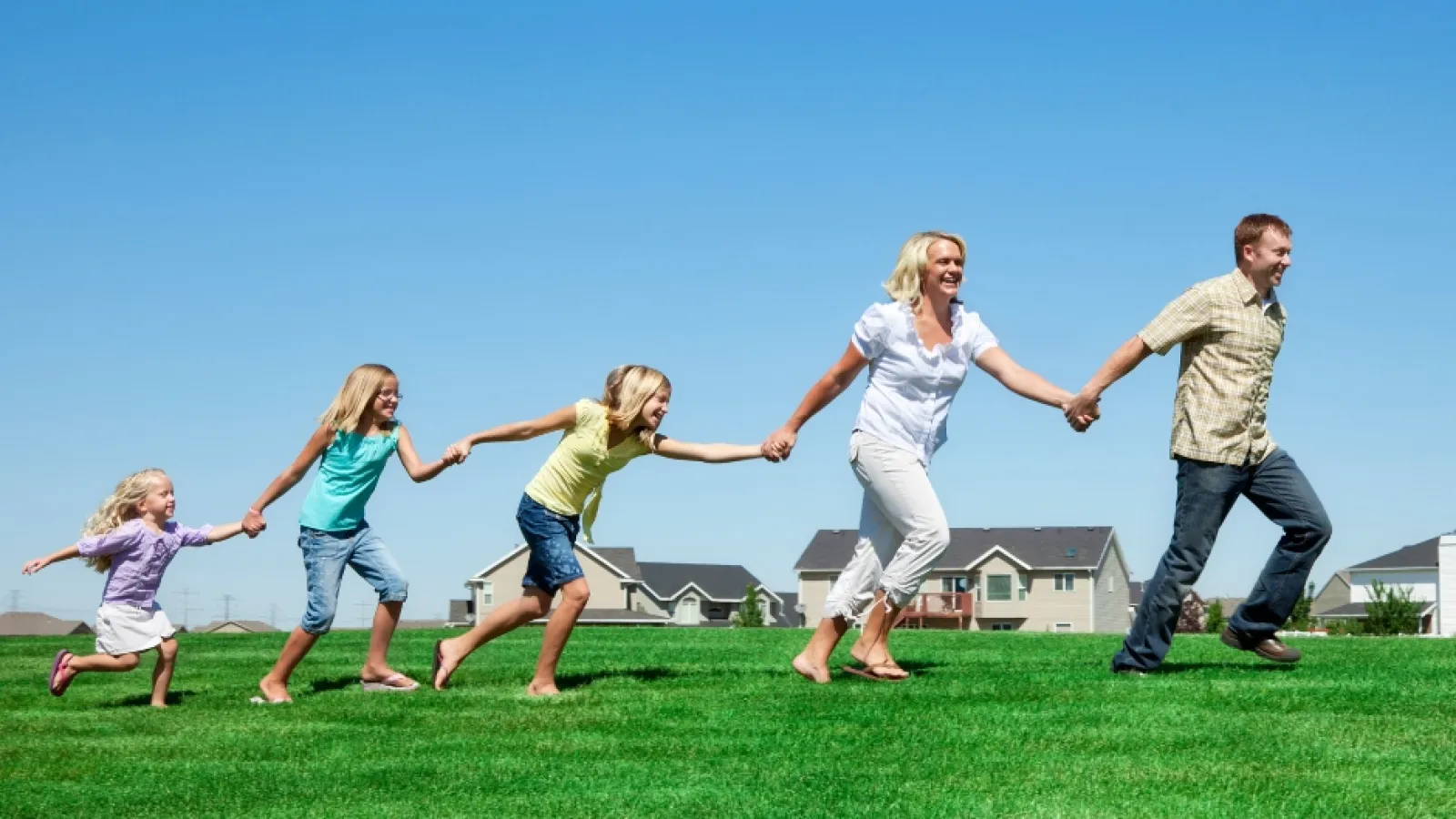 a family running on a grass field