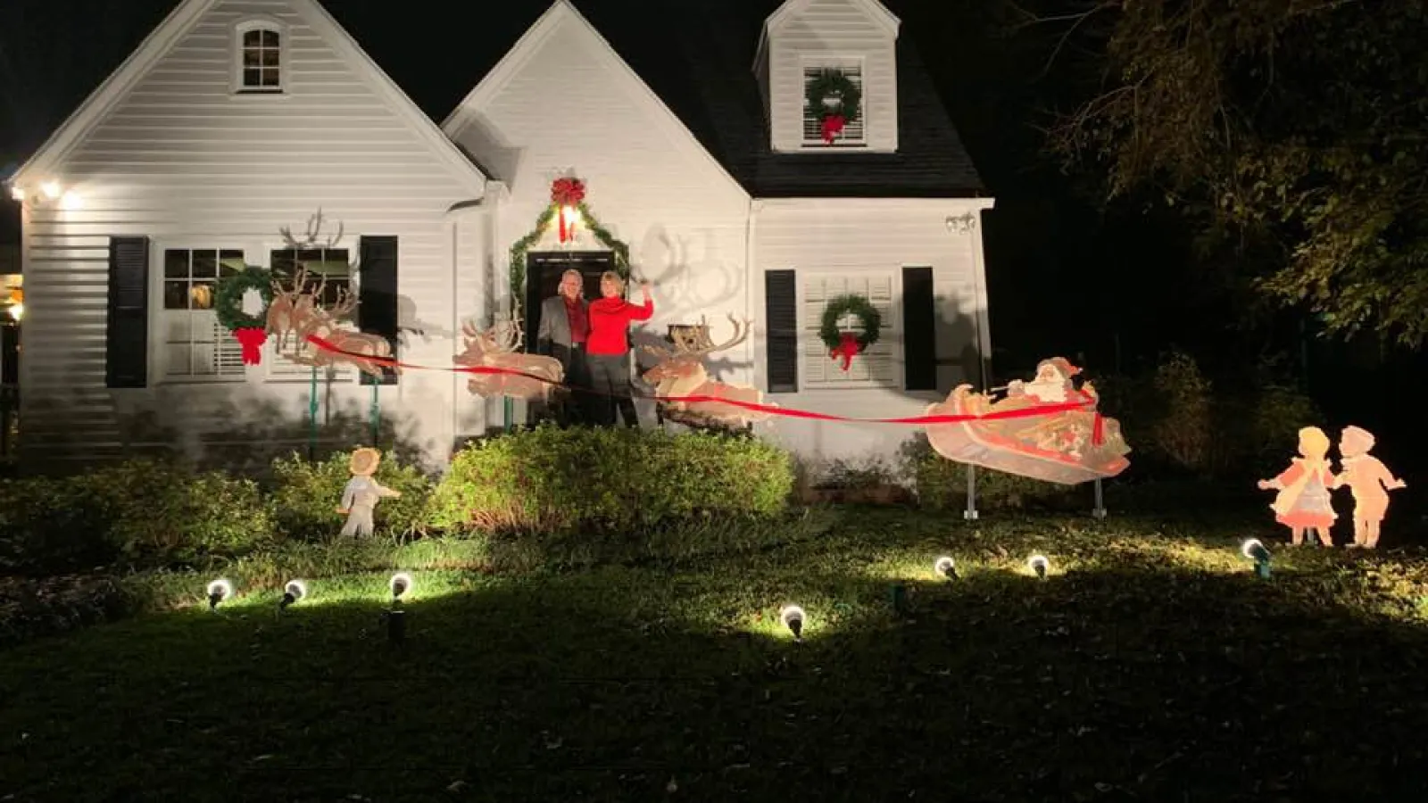 White house lit up at night with christmas decorations