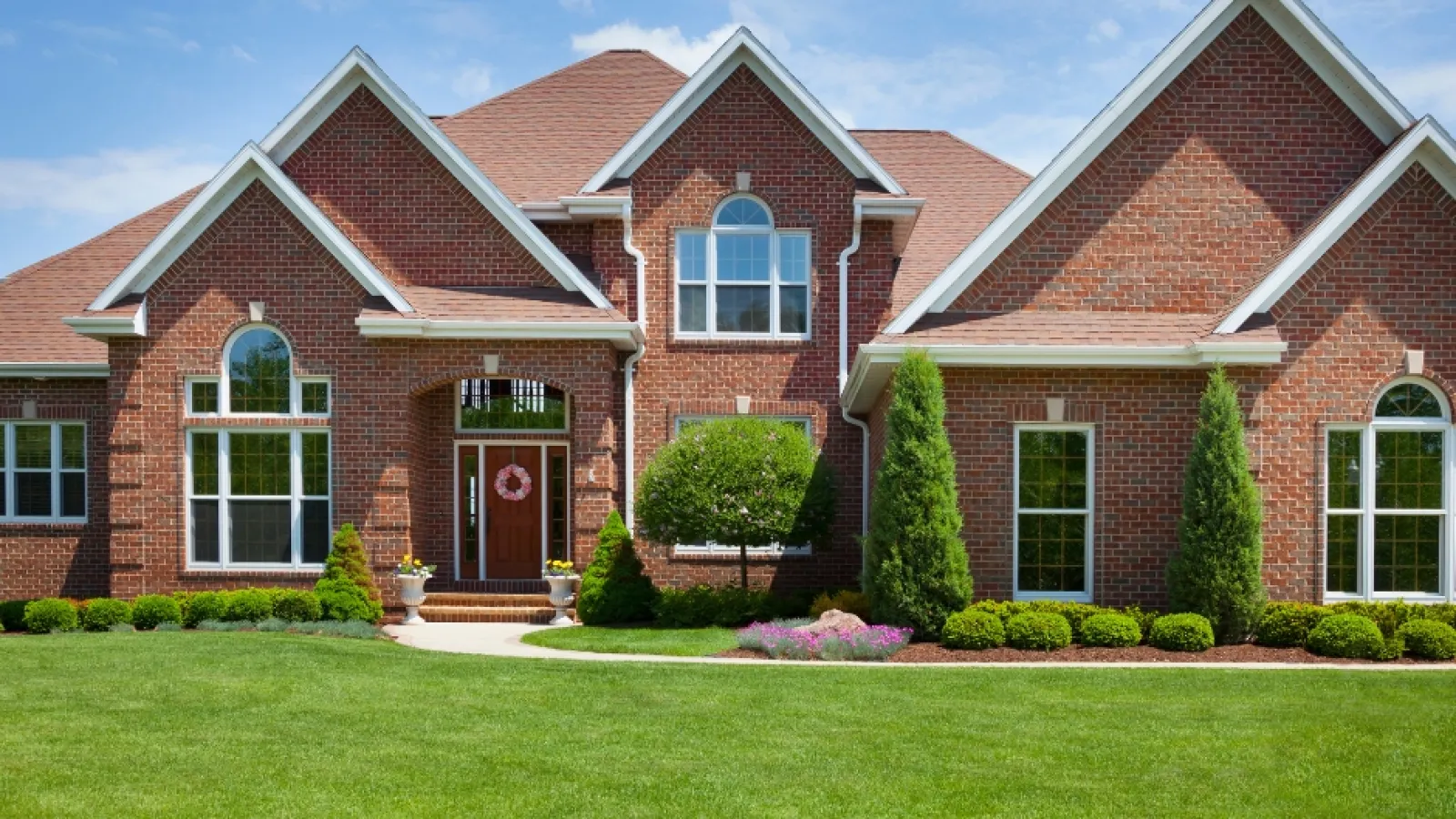 a brick house with a lawn in front of it