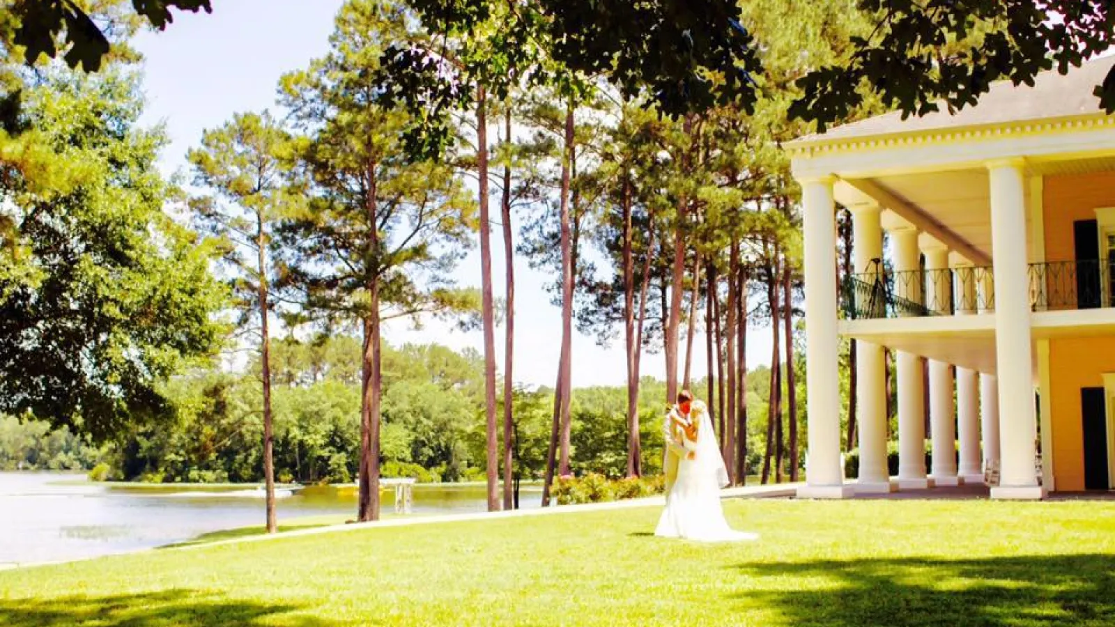 White building with pretty grass and a couple getting married