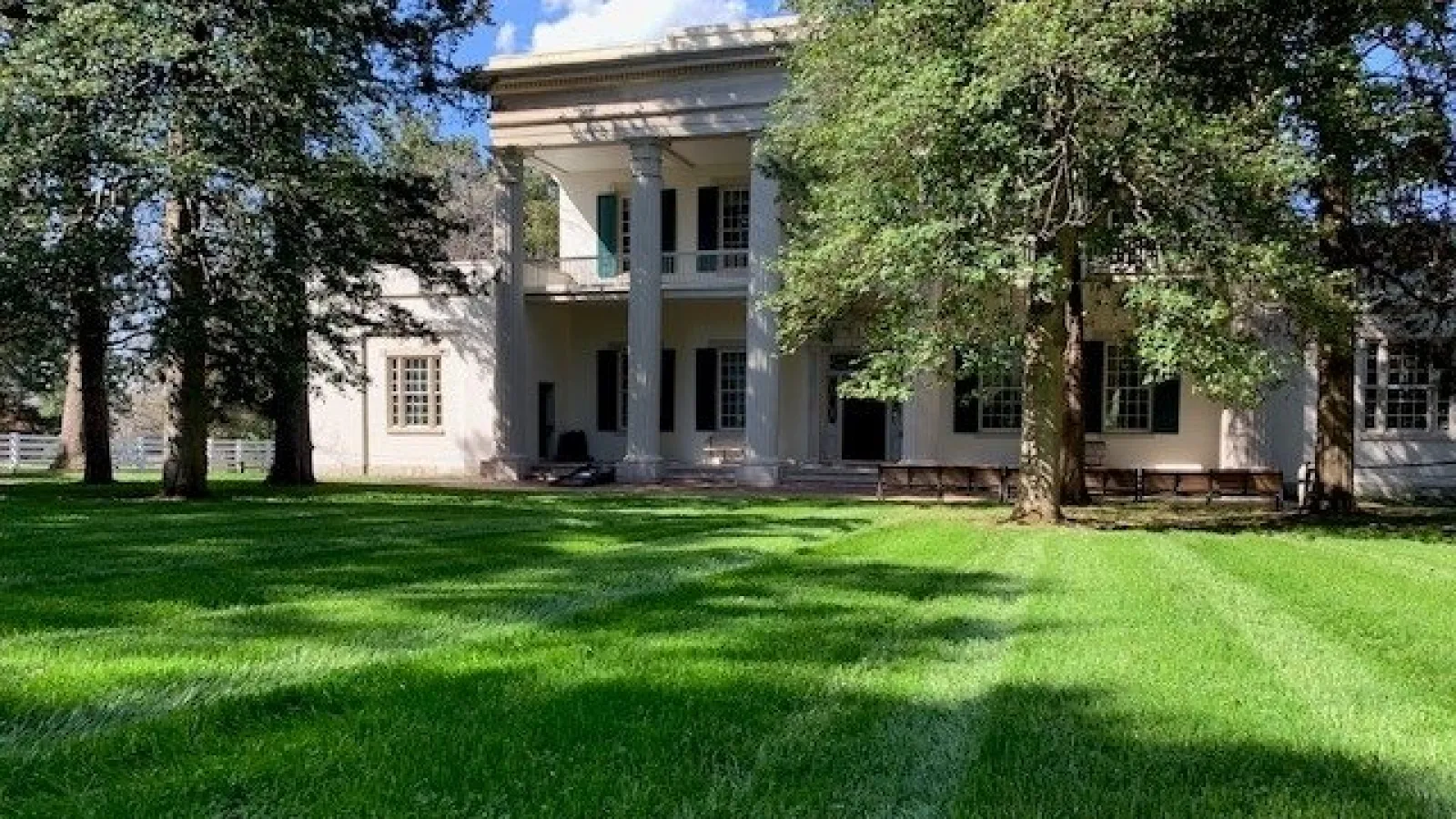 white house with columns with pretty grass