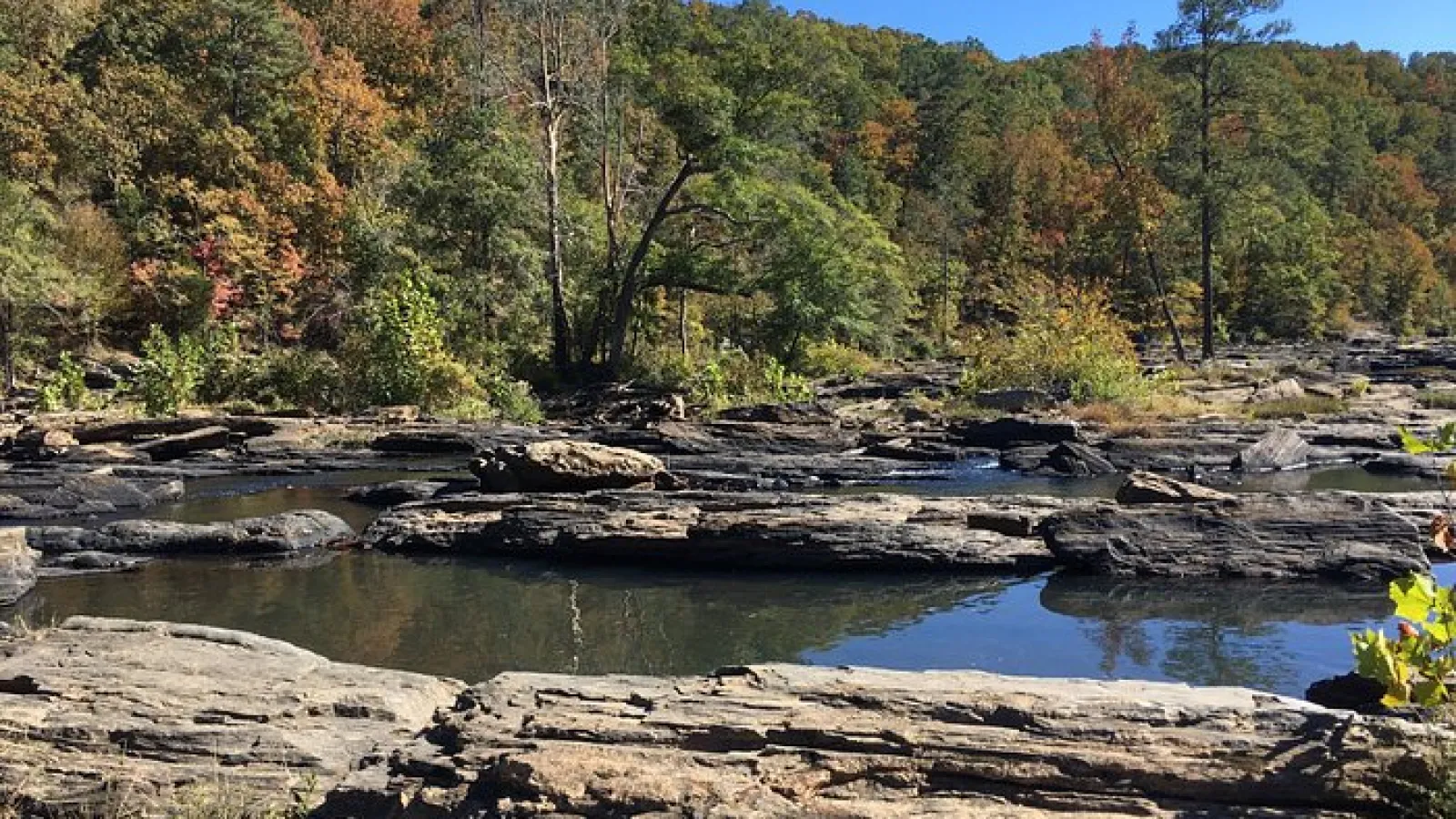 water area surrounded by rocks and trees