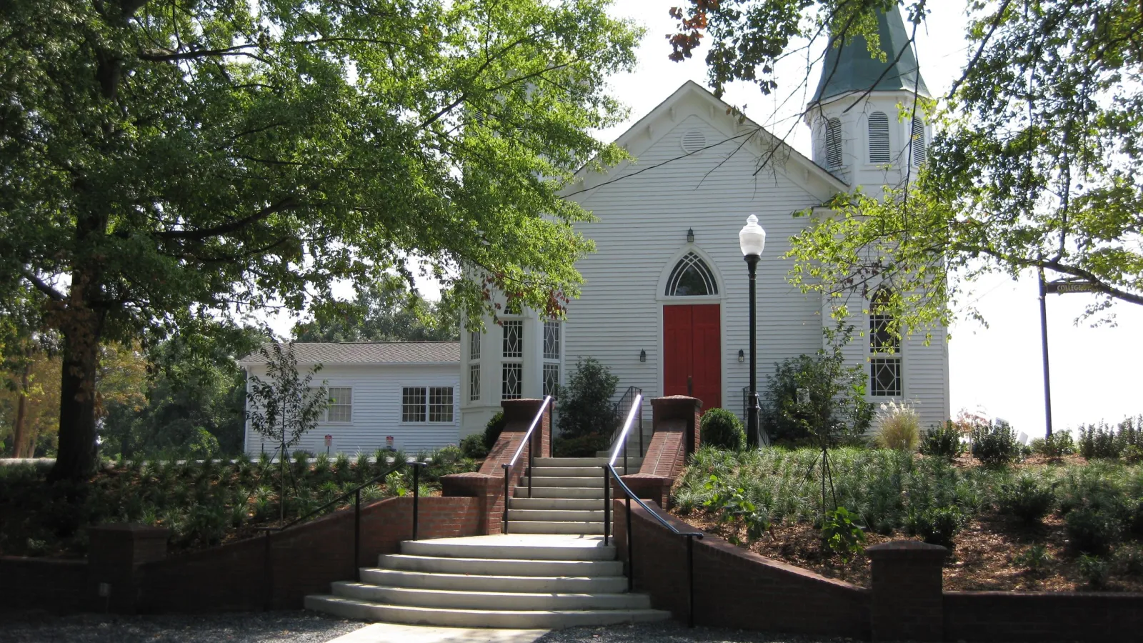 a white house with stairs and trees