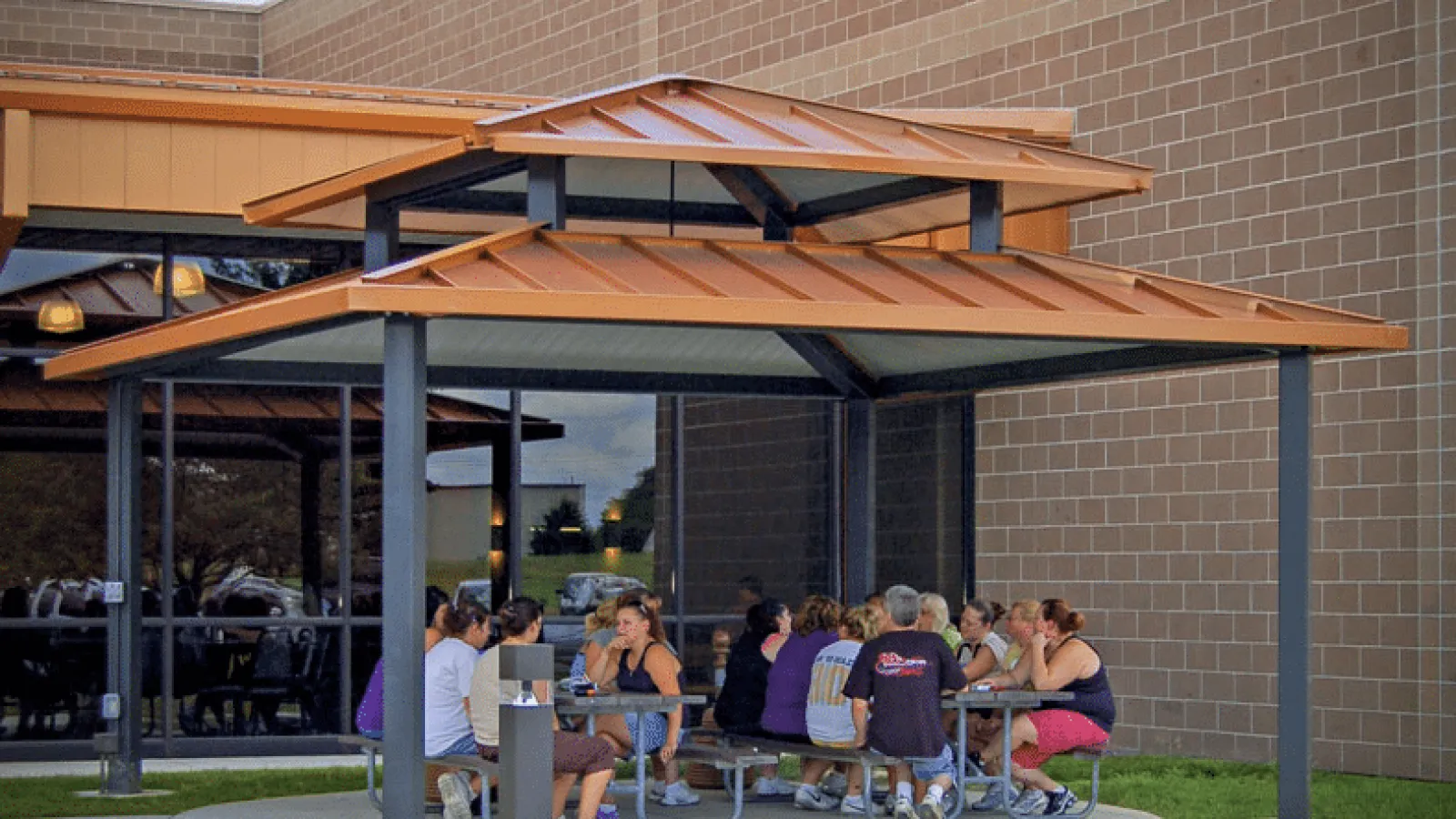 a group of people sitting at a table outside a building