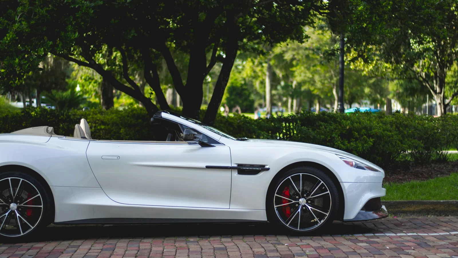 a white sports car parked on a brick road