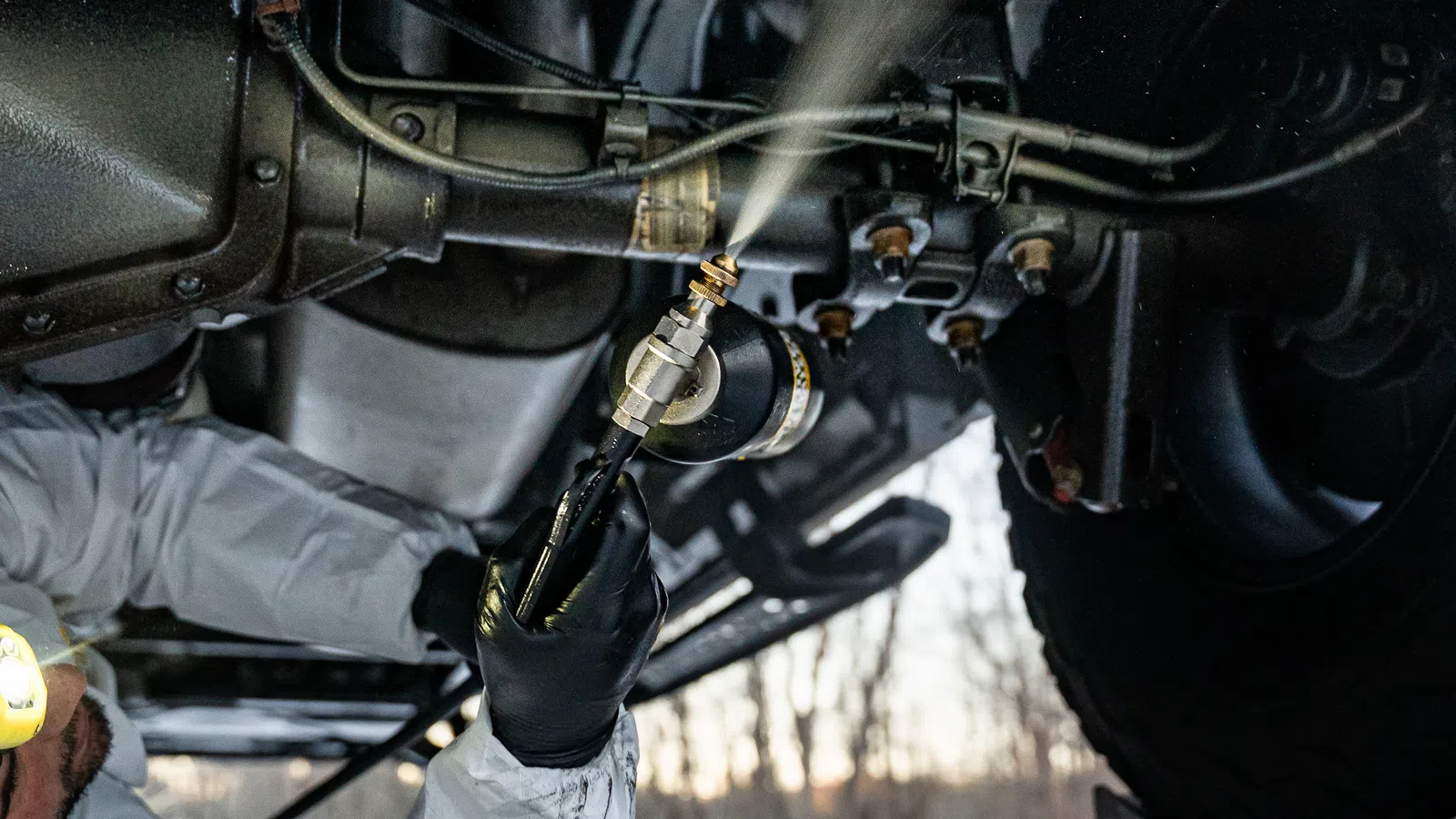 Man undercoating a vehicle