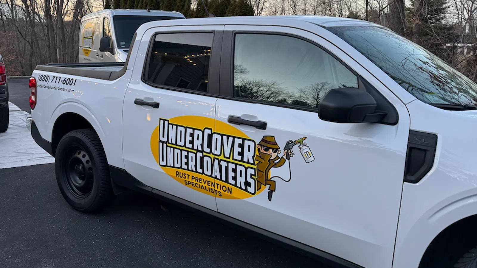 White pickup truck with UnderCover Undercoaters branding, specializing in rust prevention services.
