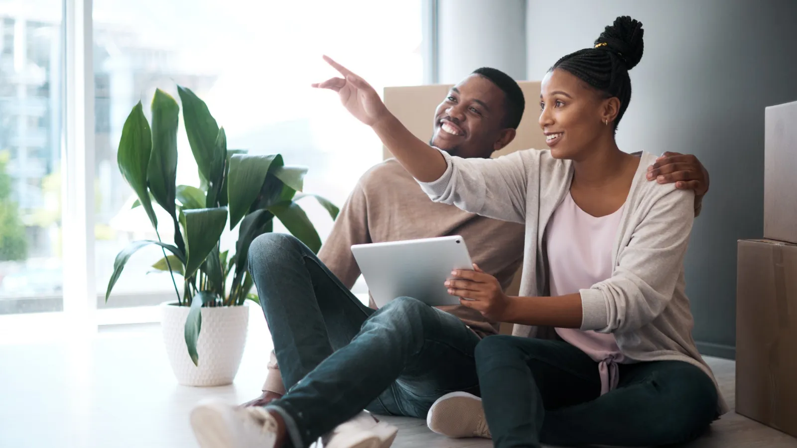 a man and a woman sitting on a couch and looking at a laptop