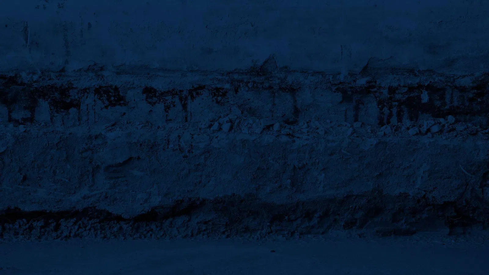 Dark textured blue wall with cracked paint and rough stone beneath, showing weathered, aged surface details.