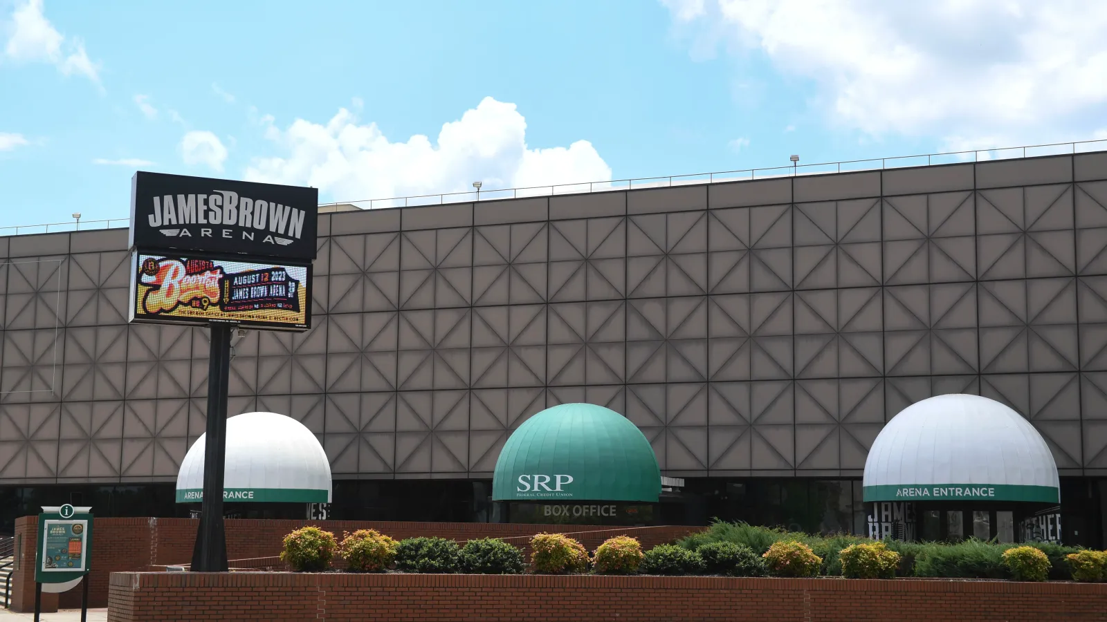 James Brown Arena exterior with signage, box office, and entrance canopies on a clear day.