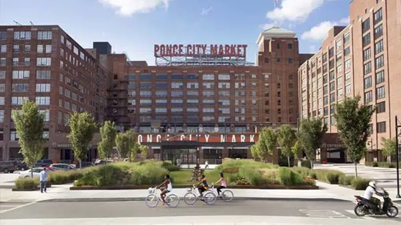 Ponce City Market historic brick building with cyclists and motorcyclist on street in vibrant urban setting