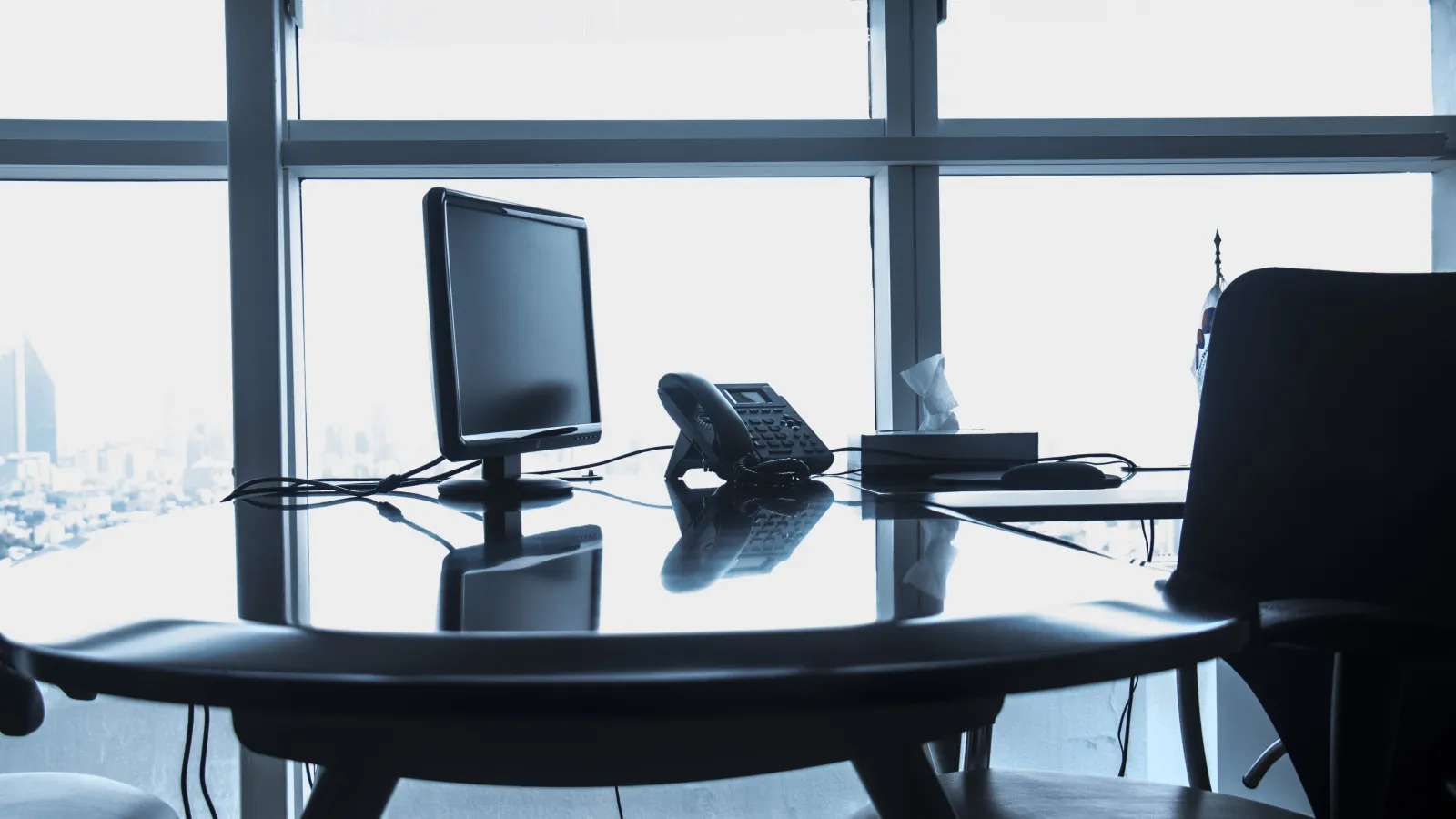 a desk with a computer and a gun on it