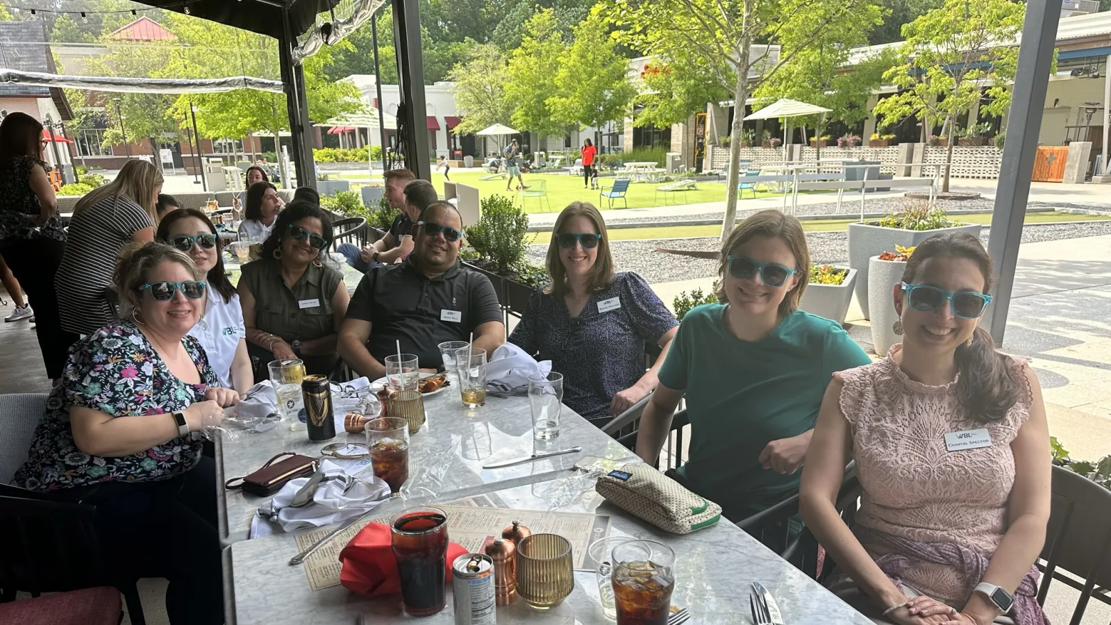 a group of people sitting at a table outside