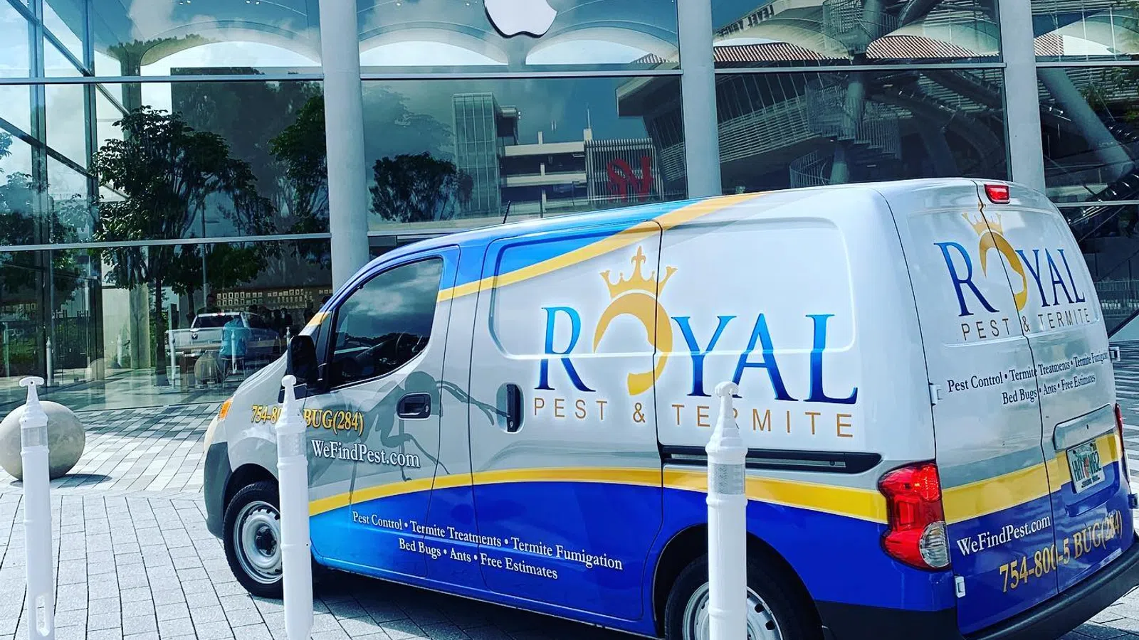 Royal Pest & Termite service van parked outside a modern building with Apple logo on glass facade