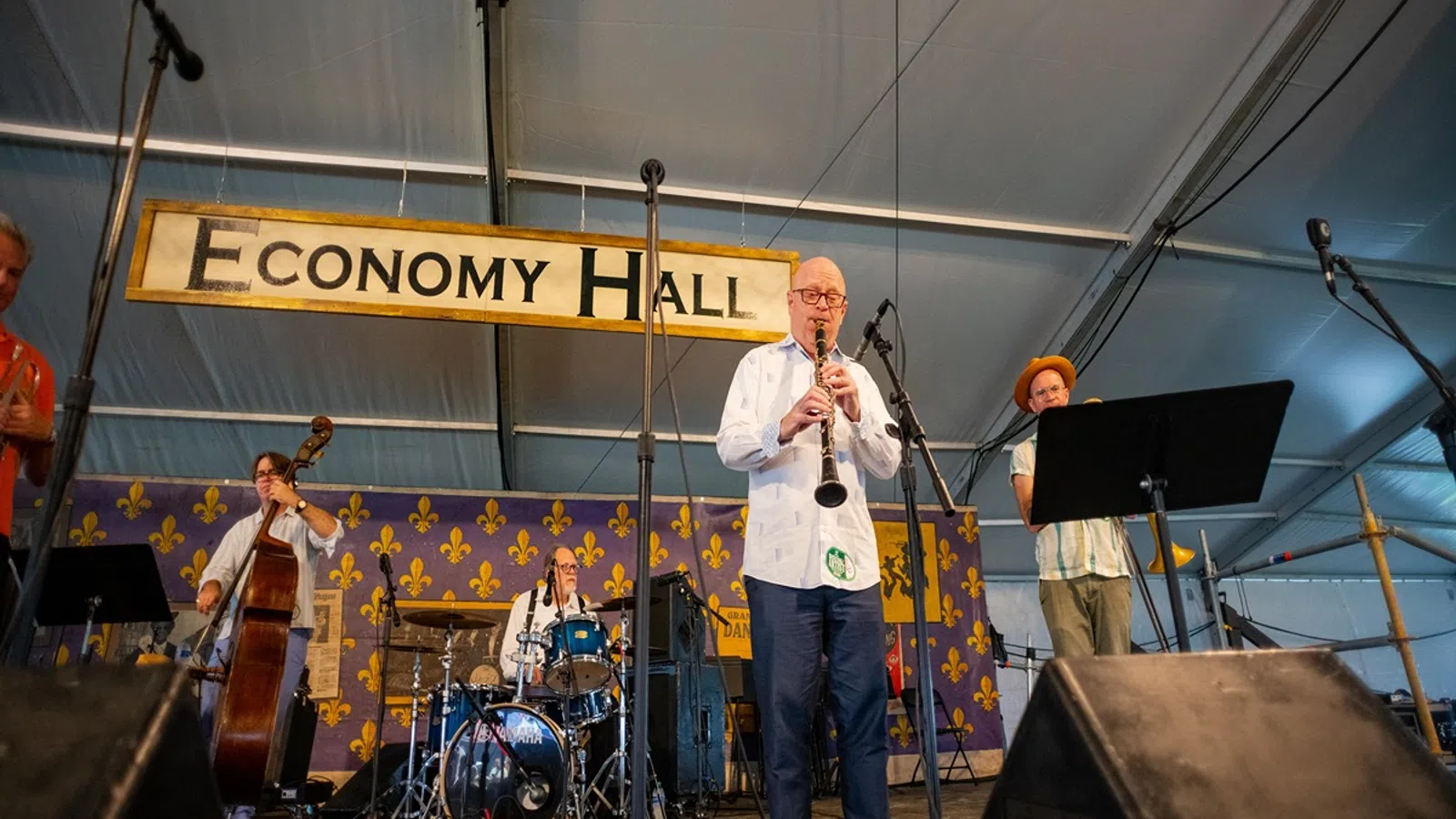 Jazz band performing live on stage under Economy Hall sign in a music festival tent setting.