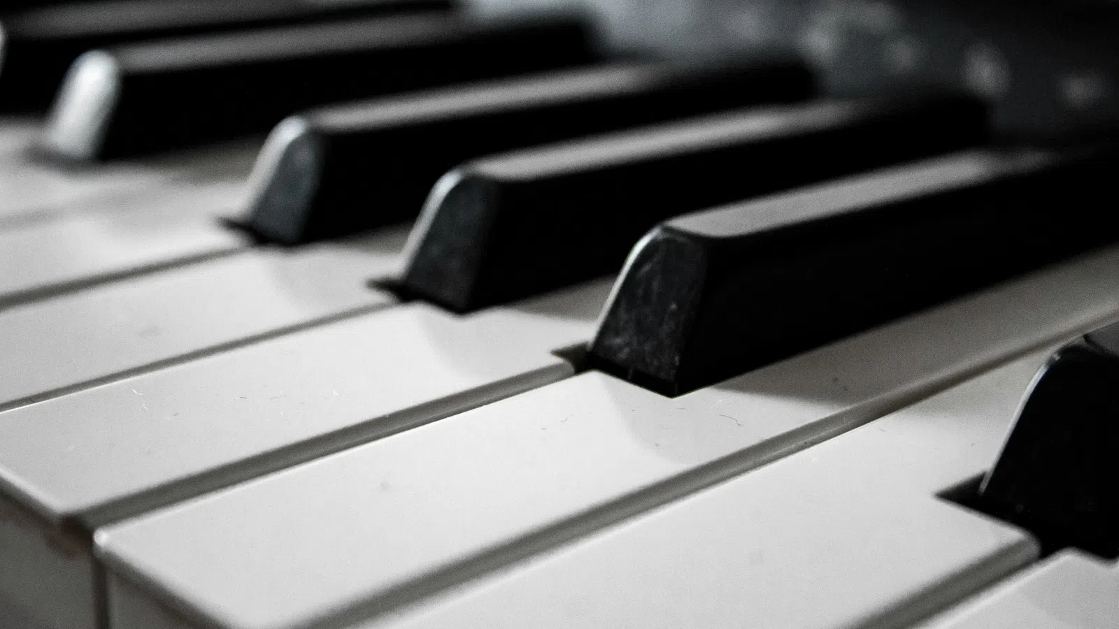 Close-up view of black and white piano keys arranged in repeating pattern on keyboard.