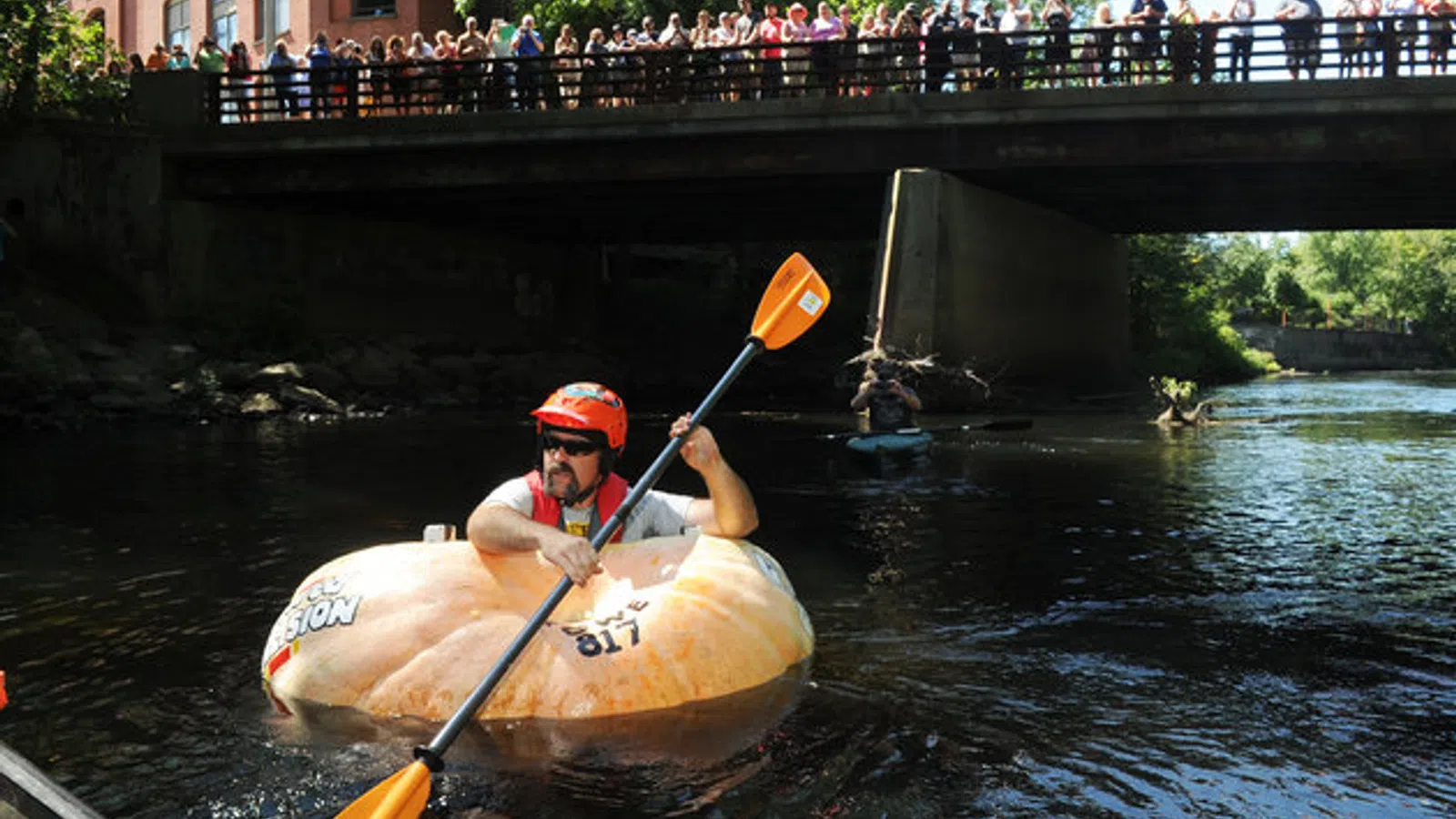 Man Paddles Down River in Pumpkin