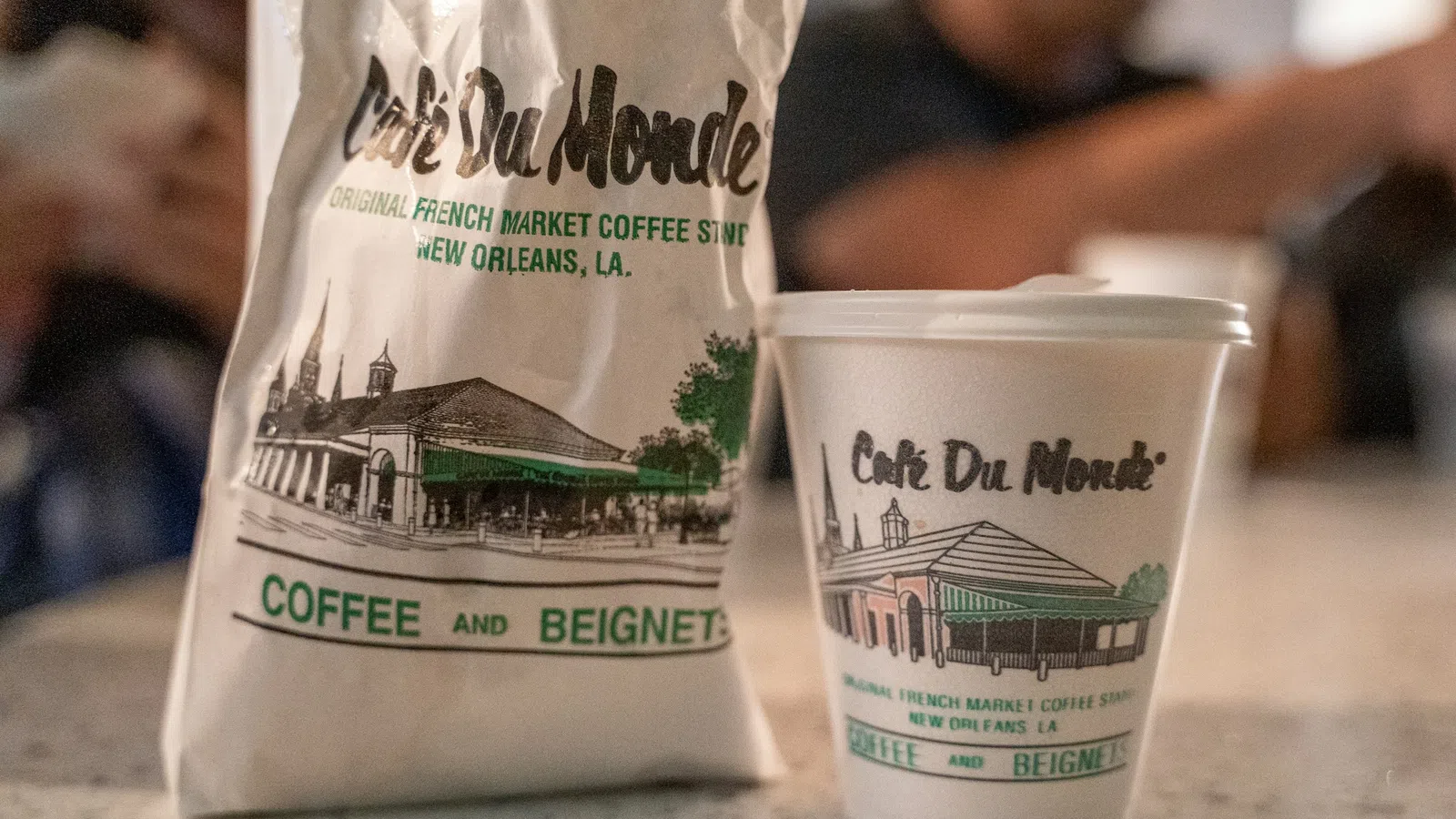 Cafe Du Monde coffee cup and bag featuring French Market coffee shop branding from New Orleans, Louisiana.