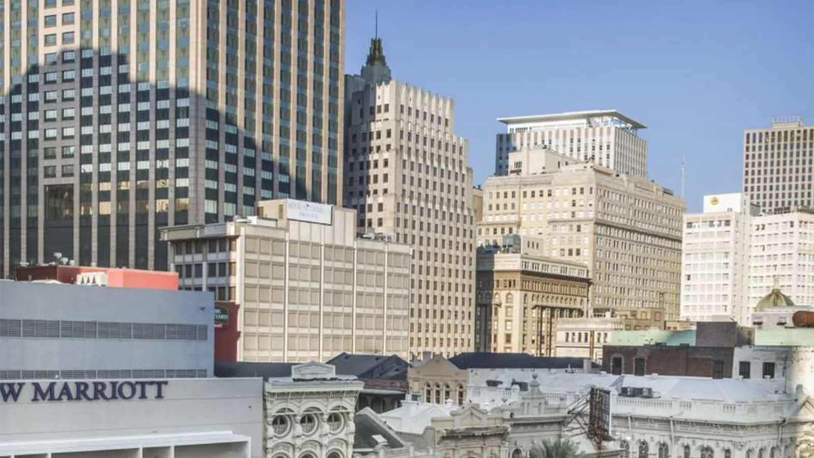 Downtown cityscape featuring a mix of historic and modern buildings under clear blue sky.