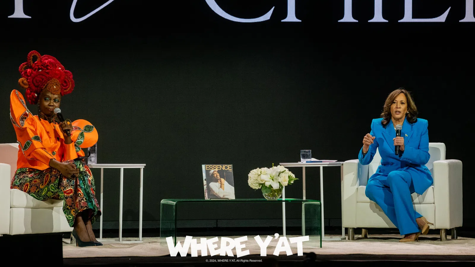 a couple of women sitting on a stage
