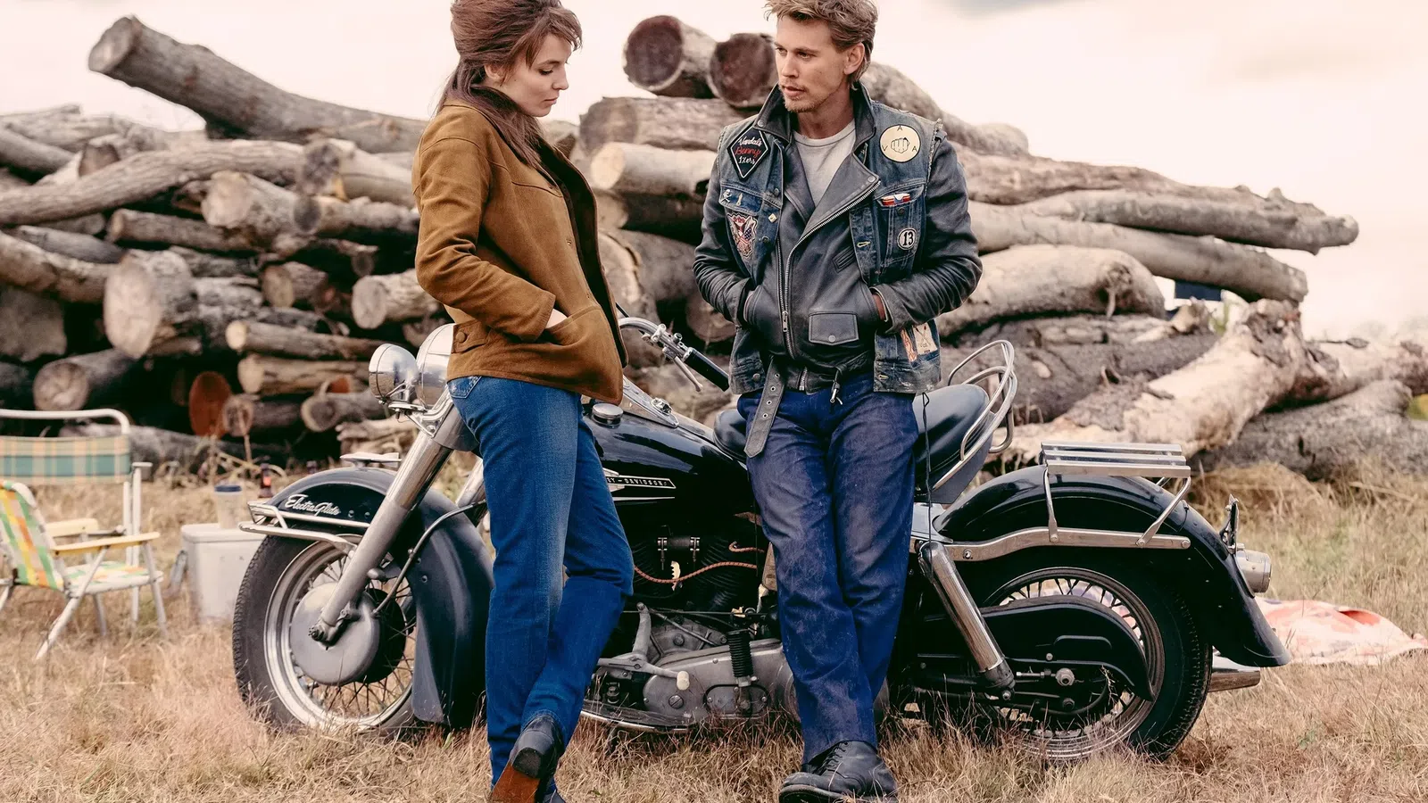 a man and woman standing next to a motorcycle