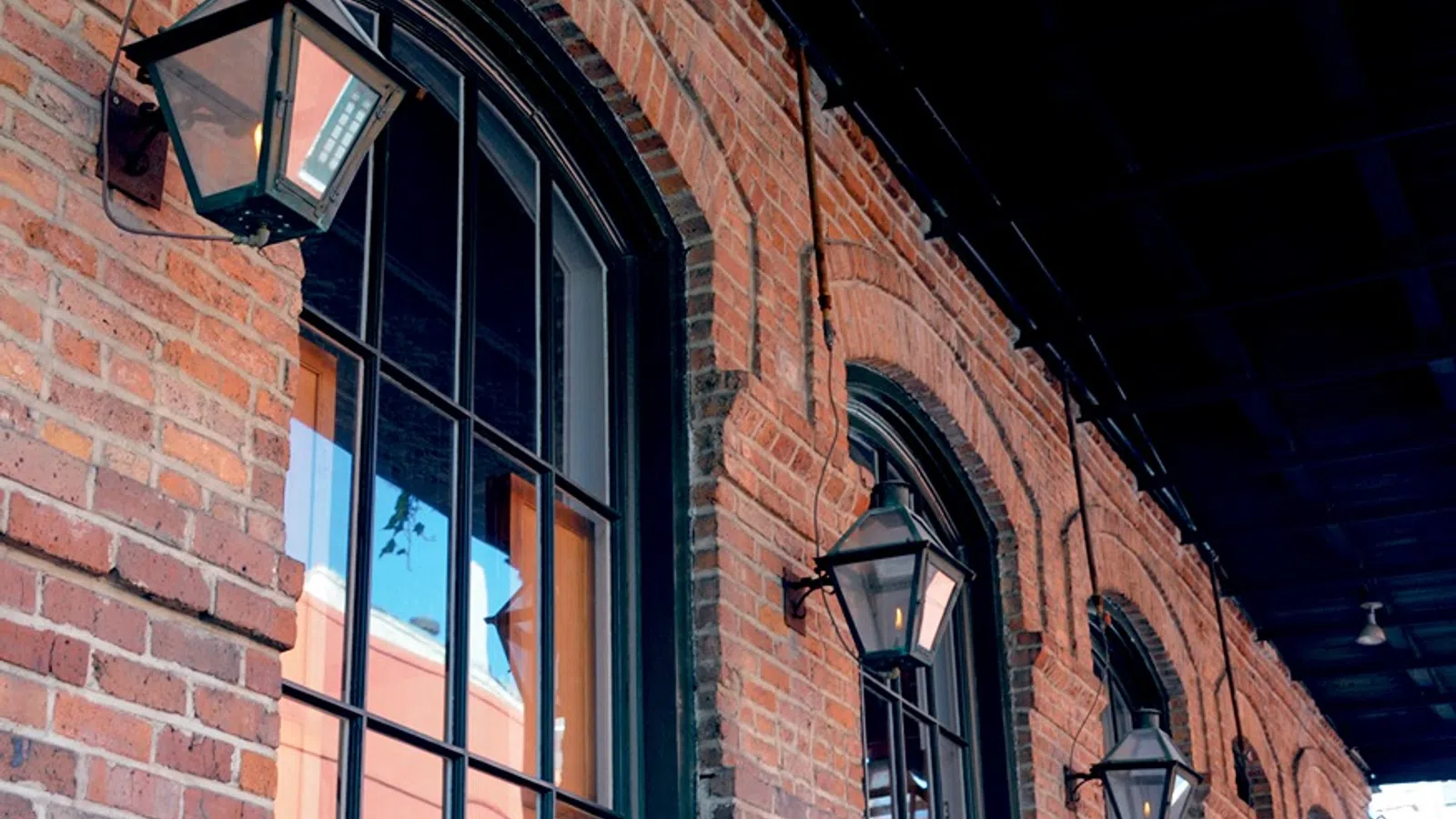 a brick building with a couple of street lamps on the side
