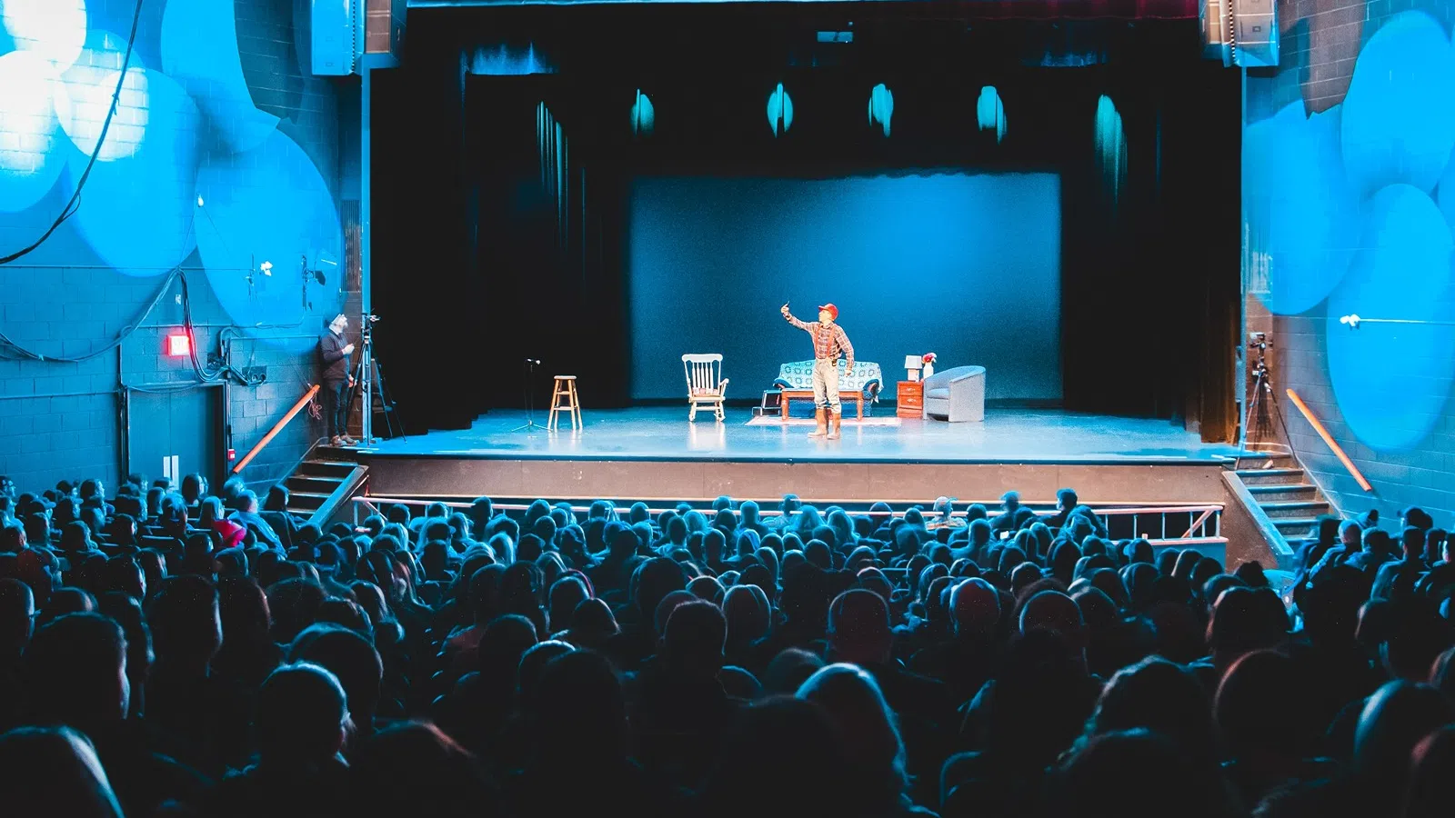 a person on a stage with a microphone in front of a large audience