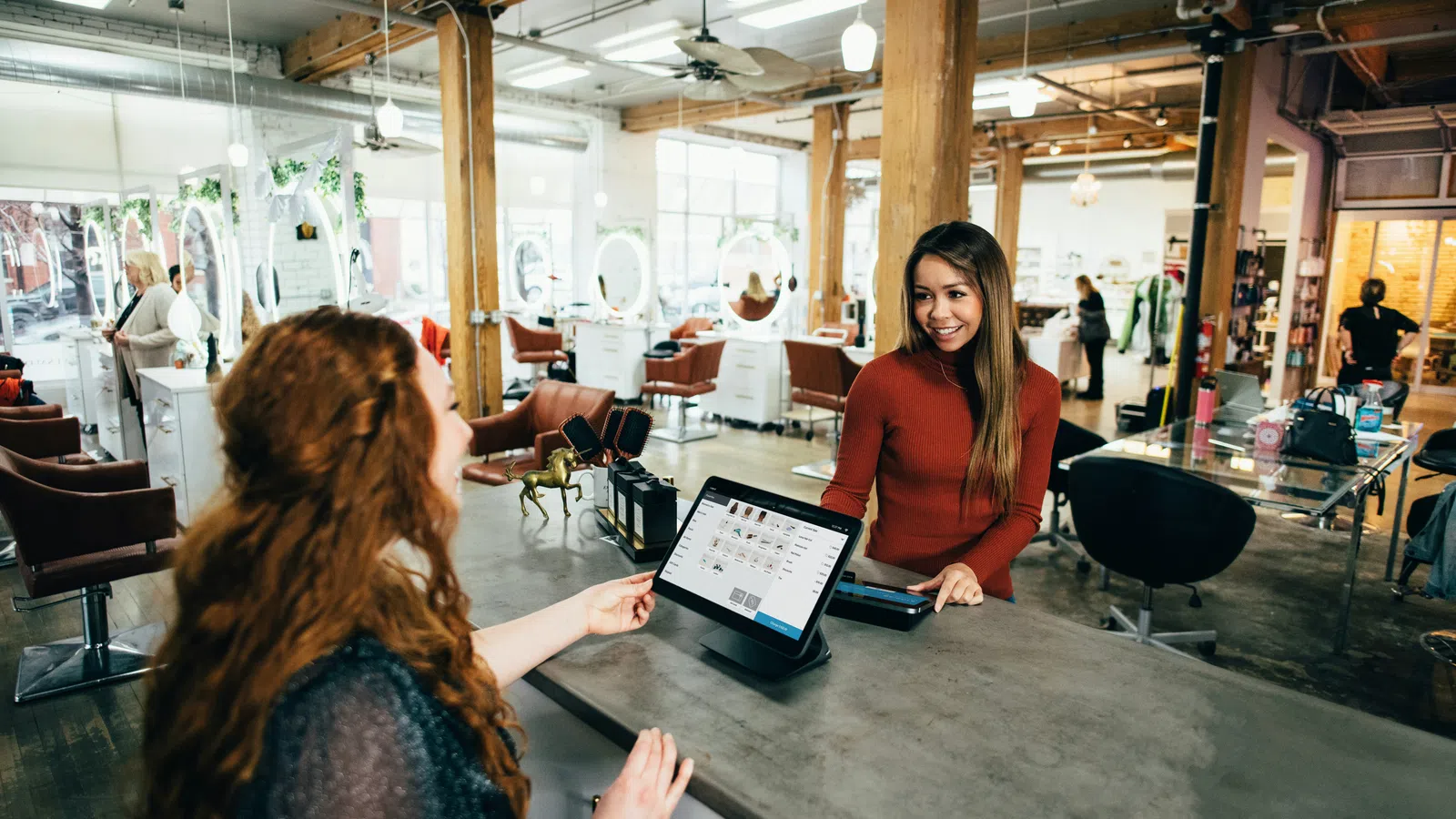 a person showing a person something on the tablet