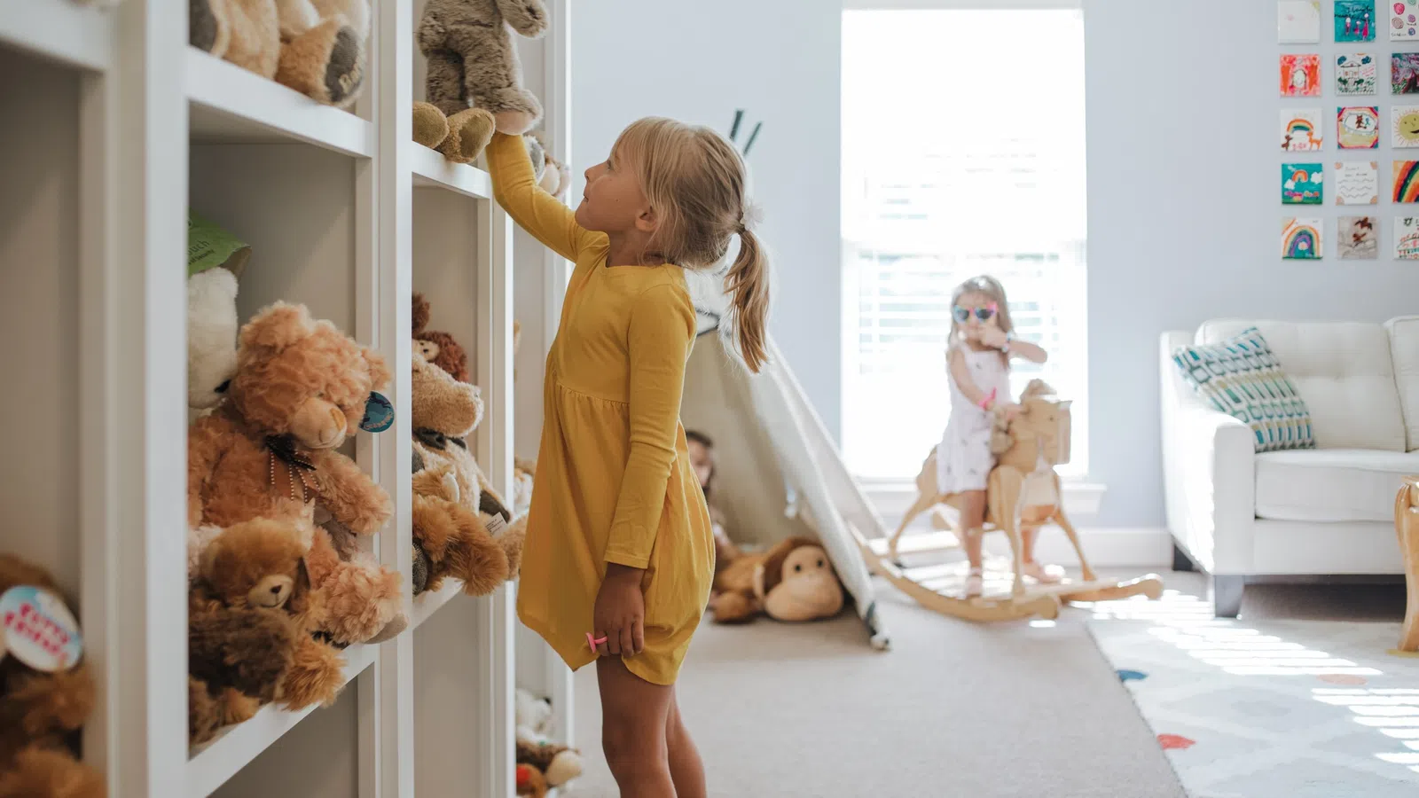 a person in a yellow dress in a room with teddy bears