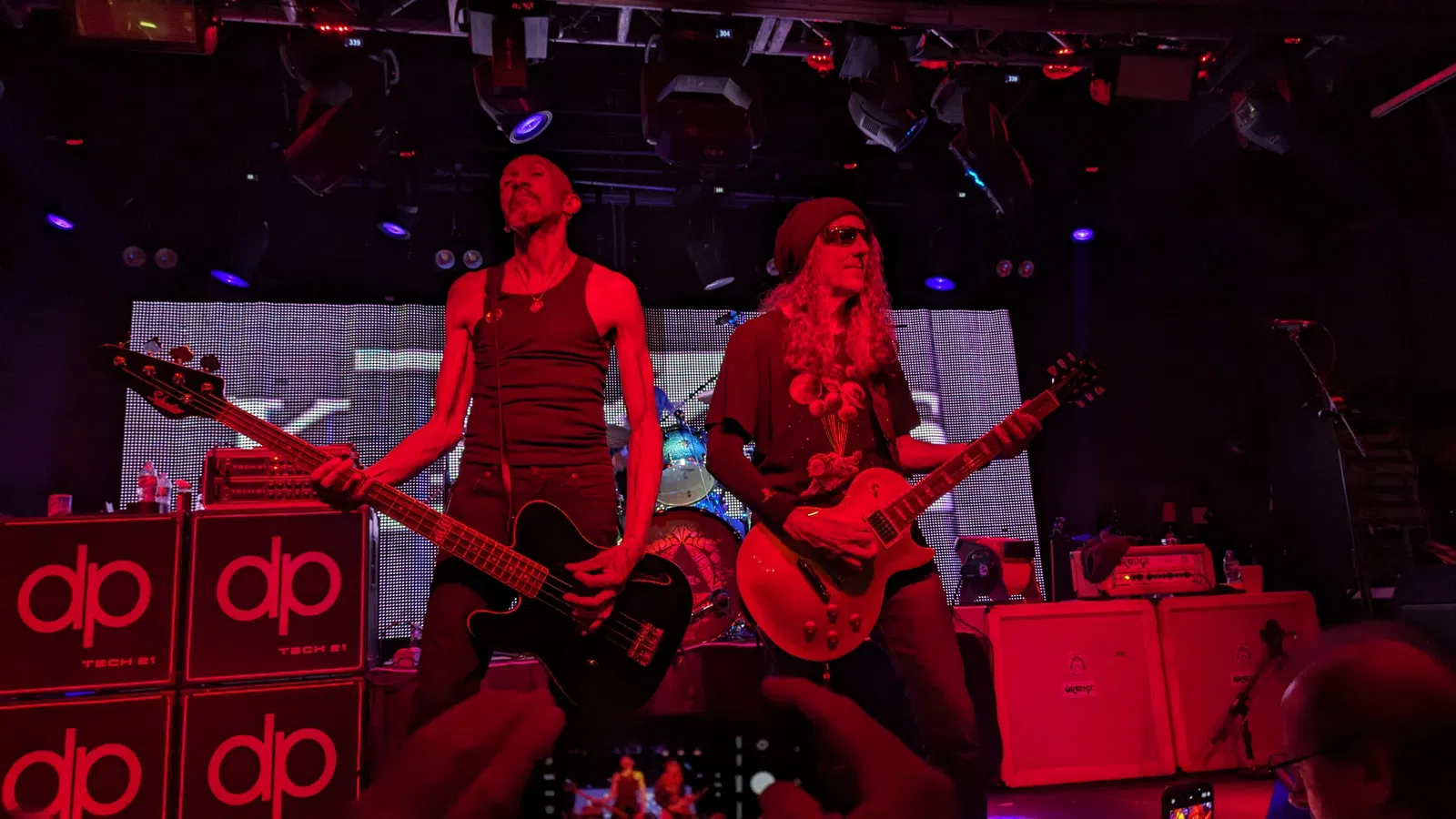 two men playing guitars on a stage