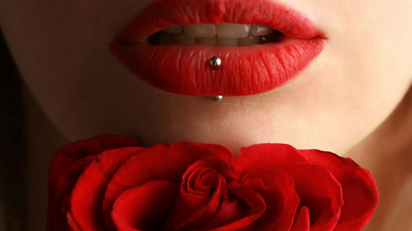 a woman's lips with a red rose in front of her