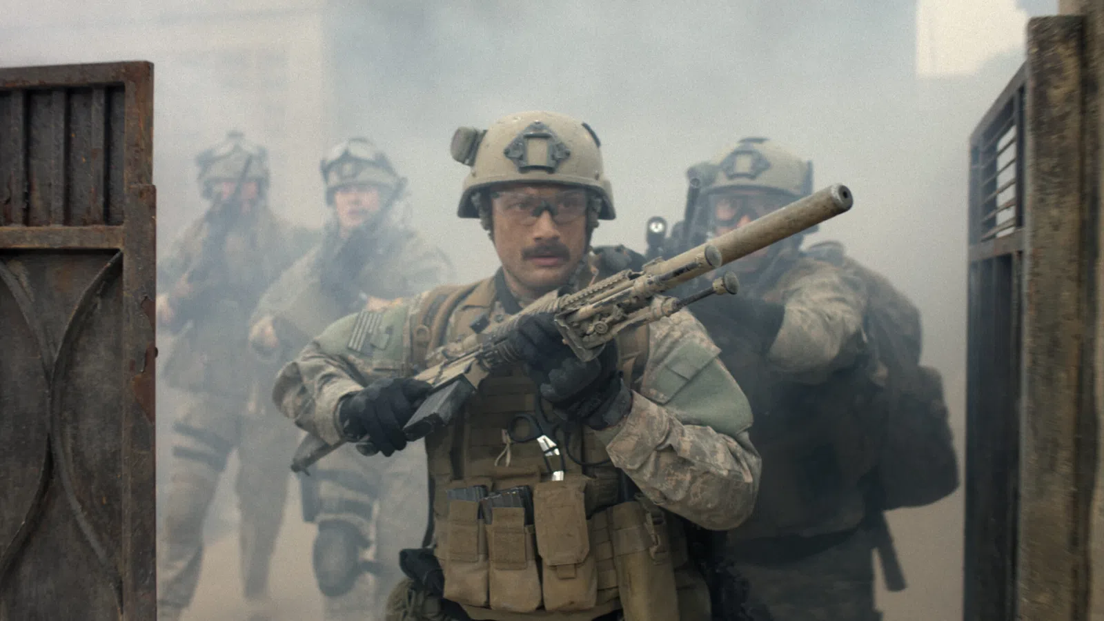 Soldiers in tactical gear advancing through smoke with weapons drawn in a dramatic military scene.