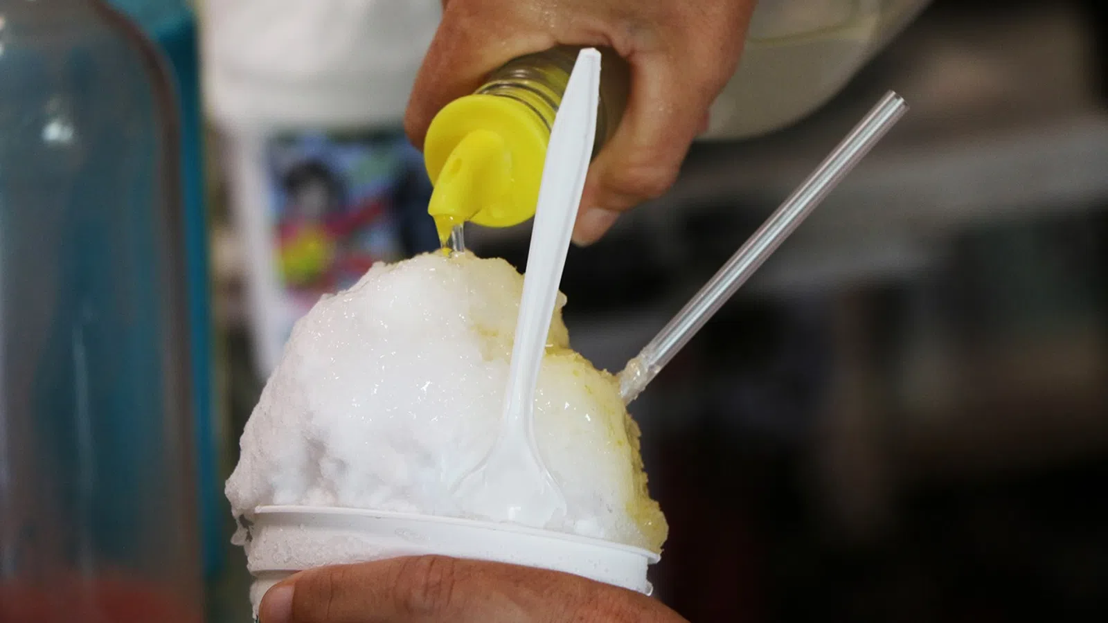 a person pouring a drink into a cup