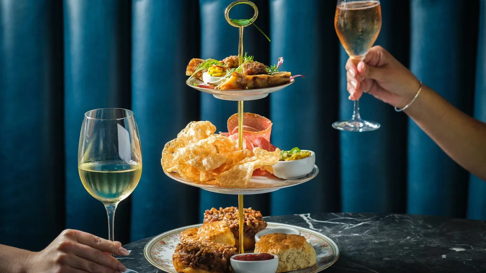 a couple of people holding wine glasses and a plate of food