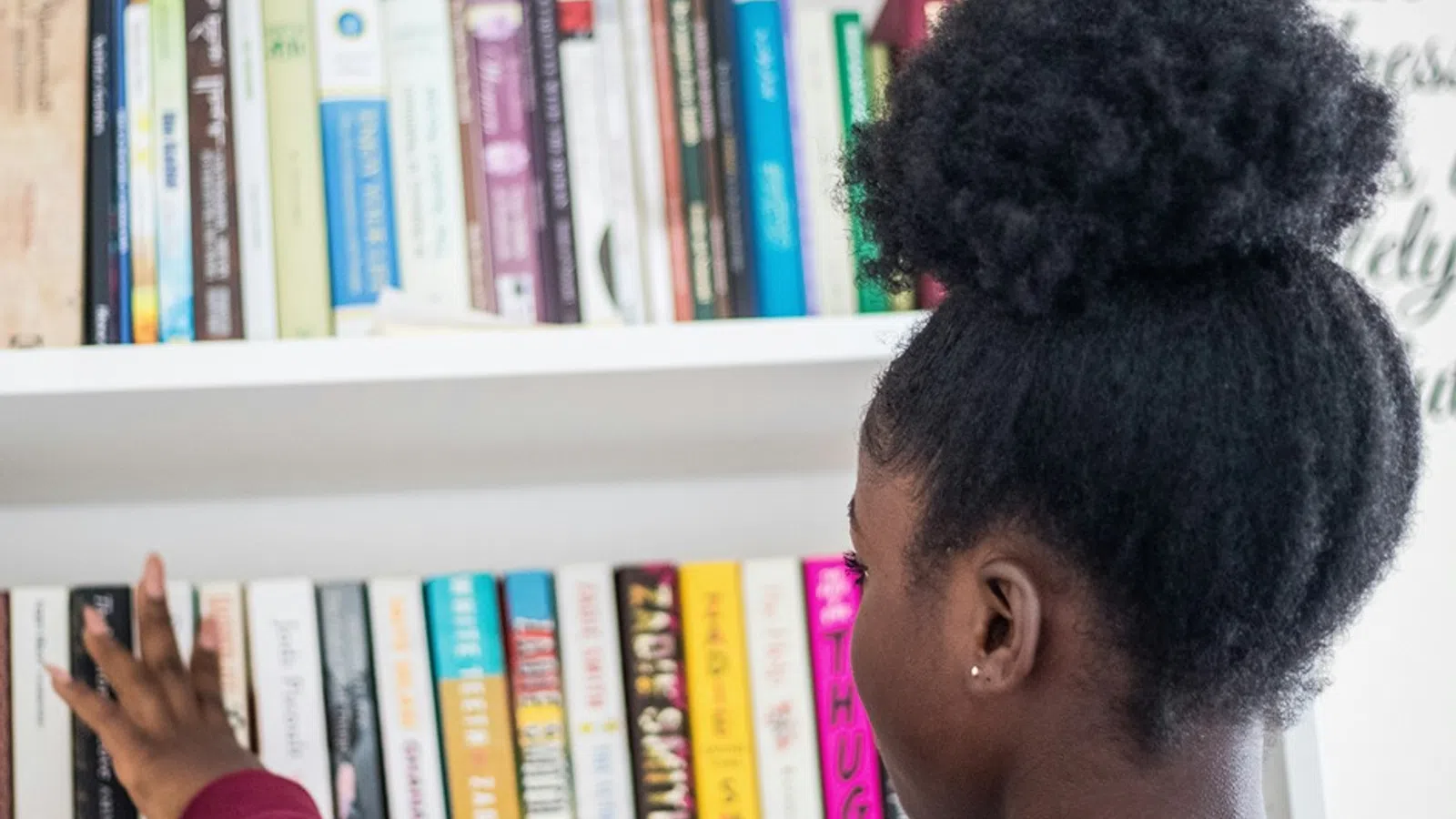 a man looking at a book shelf