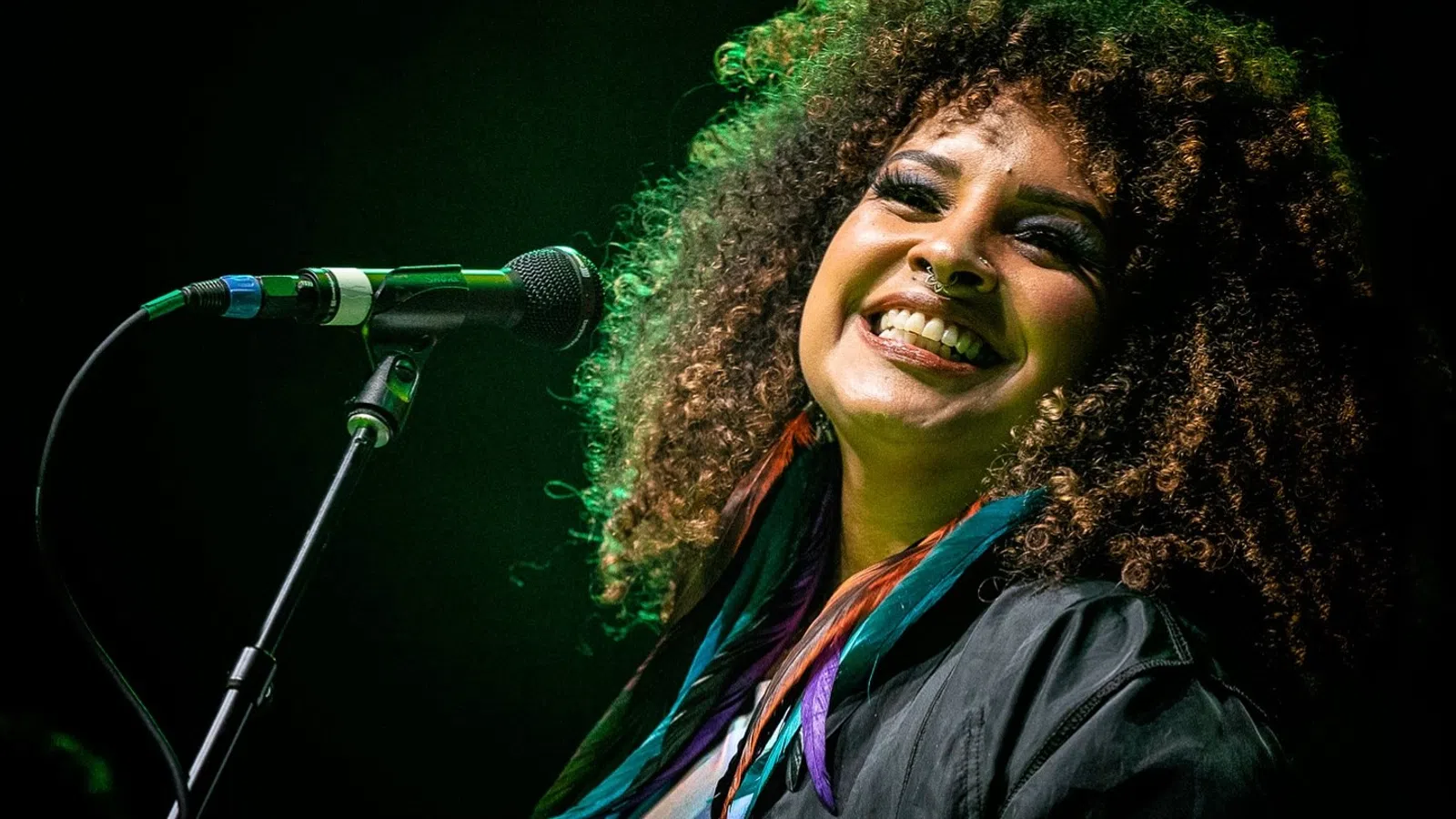 a man with curly hair smiling
