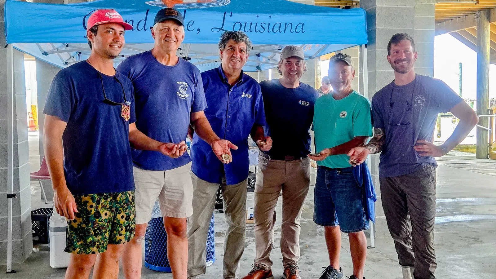 Group of fishermen showcasing their catch under a tent in Louisiana.