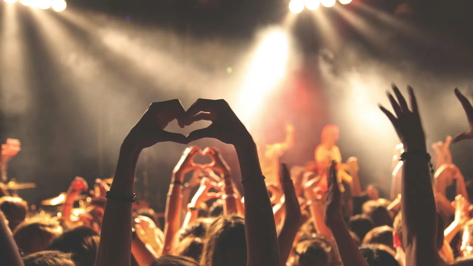 a crowd of people holding their hands up in the air