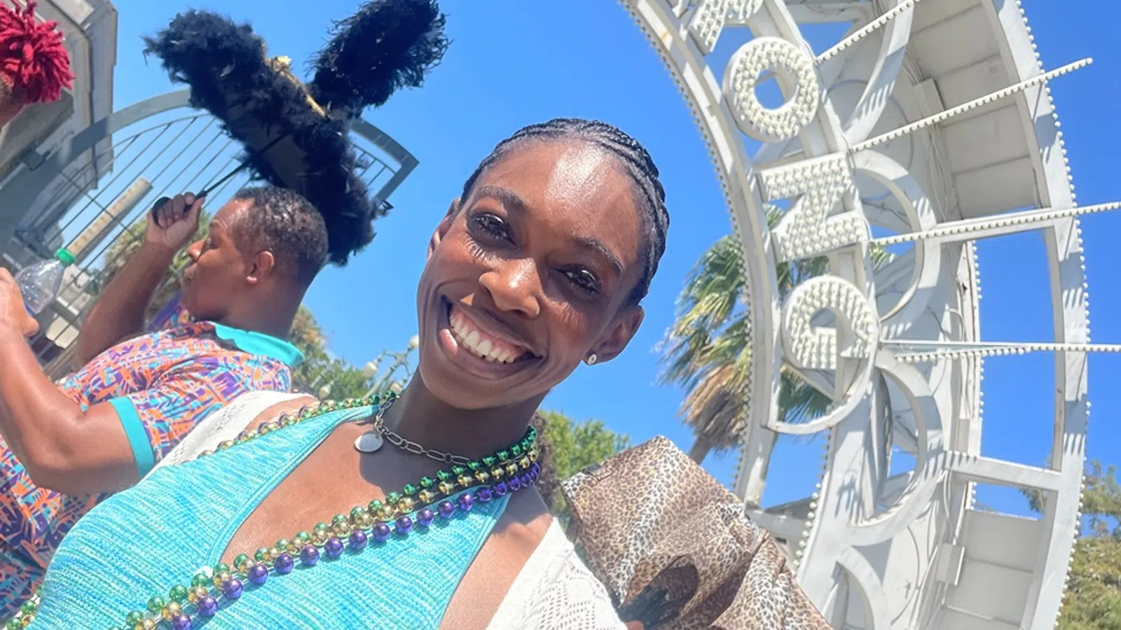a woman smiling with a man in the background