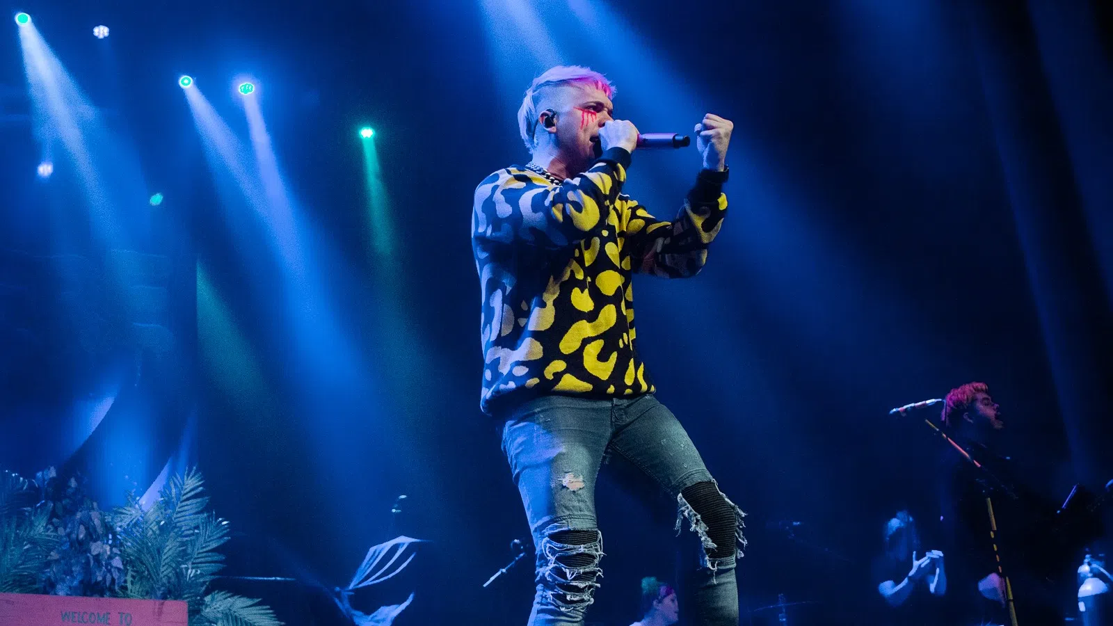 a man singing into a microphone on stage