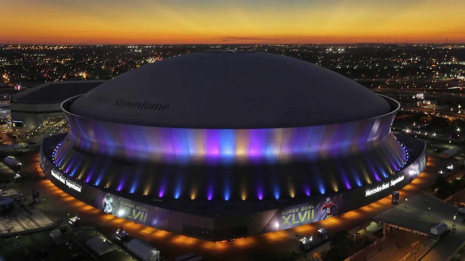 a large stadium with a large crowd of people in it with Mercedes-Benz Superdome in the background