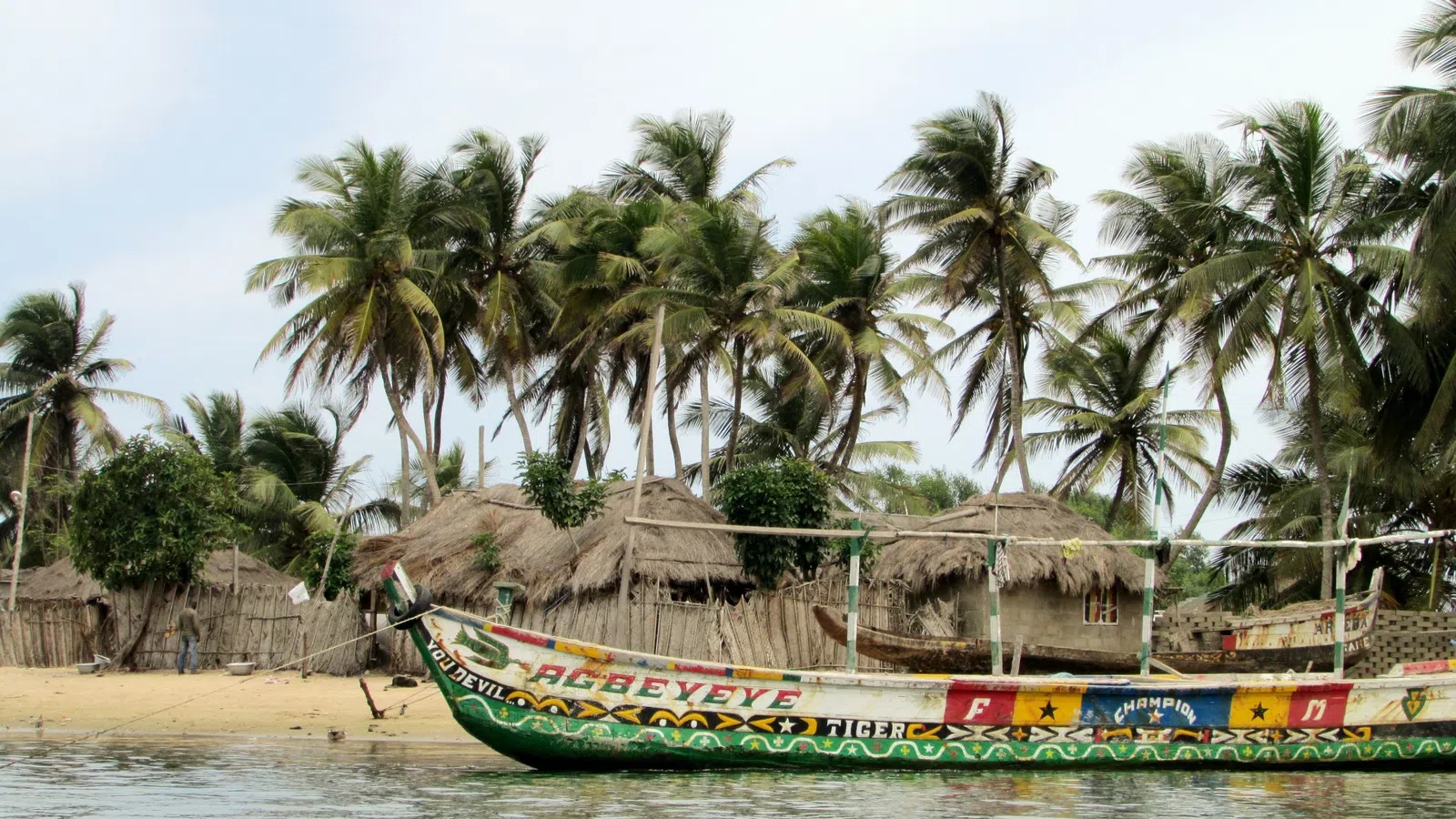 a boat with straw roofs on a beach