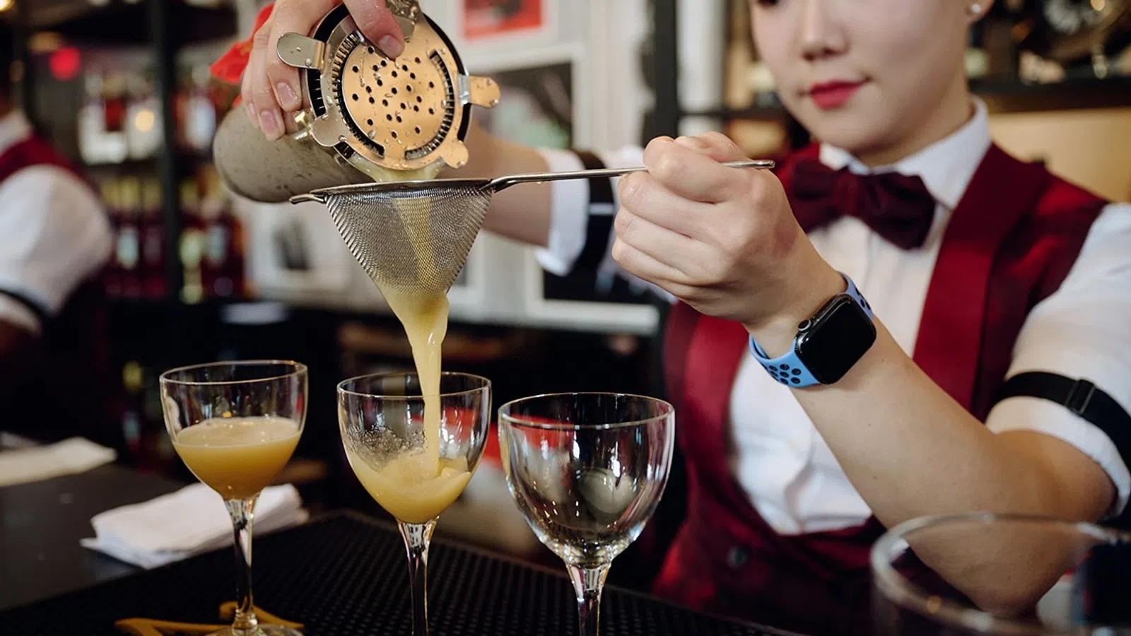 a person pouring a drink into a glass