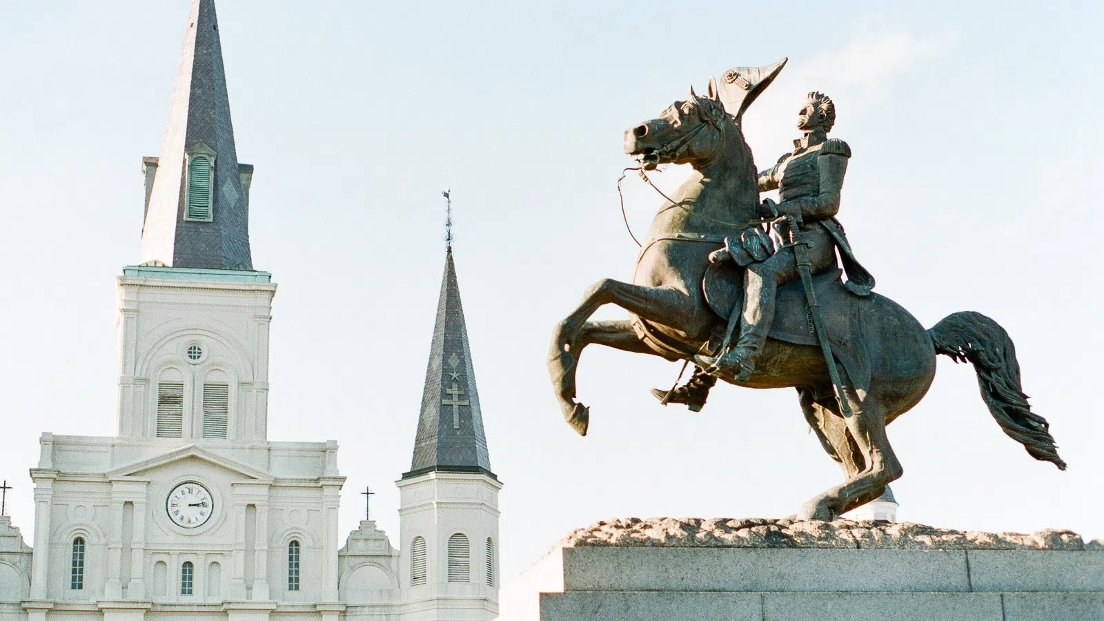 a statue of a man riding a horse in front of a white building