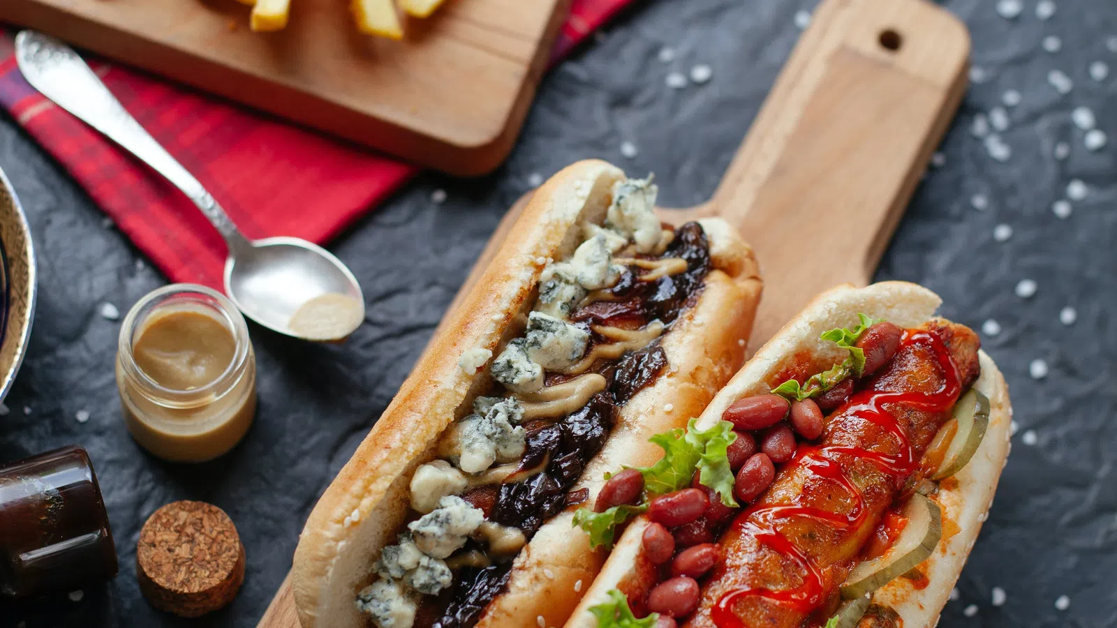 a hot dog with ketchup and mustard on a cutting board