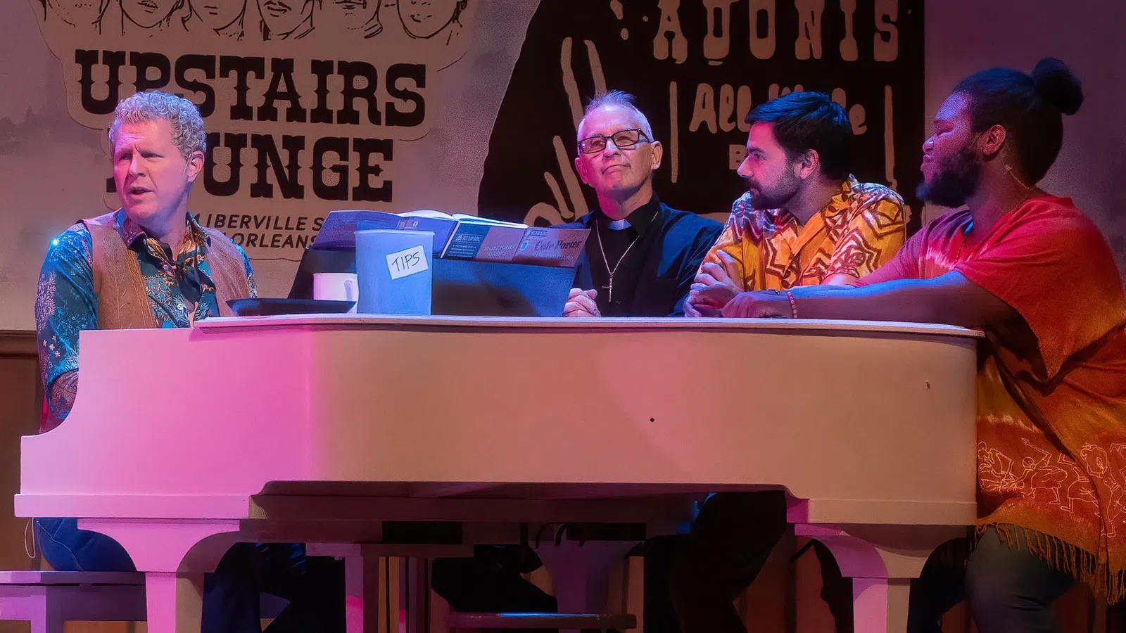 a group of men sitting at a table with a person standing behind them